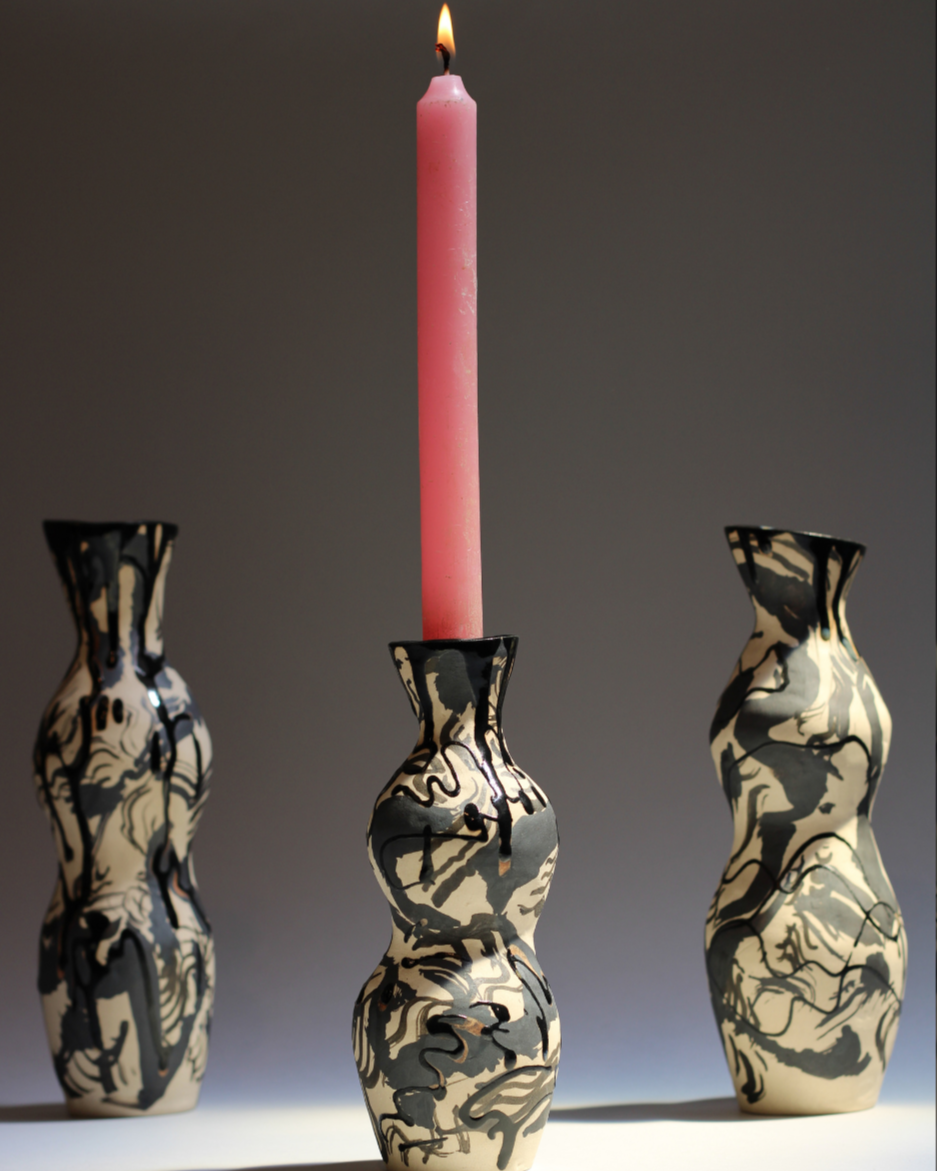 Ceramic candleholder with an organic sculptural form, featuring illustrated linework