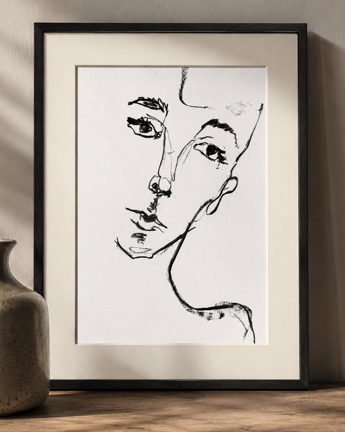 Detail of the framed linework portrait of a face made through black gestural lines in a white background
