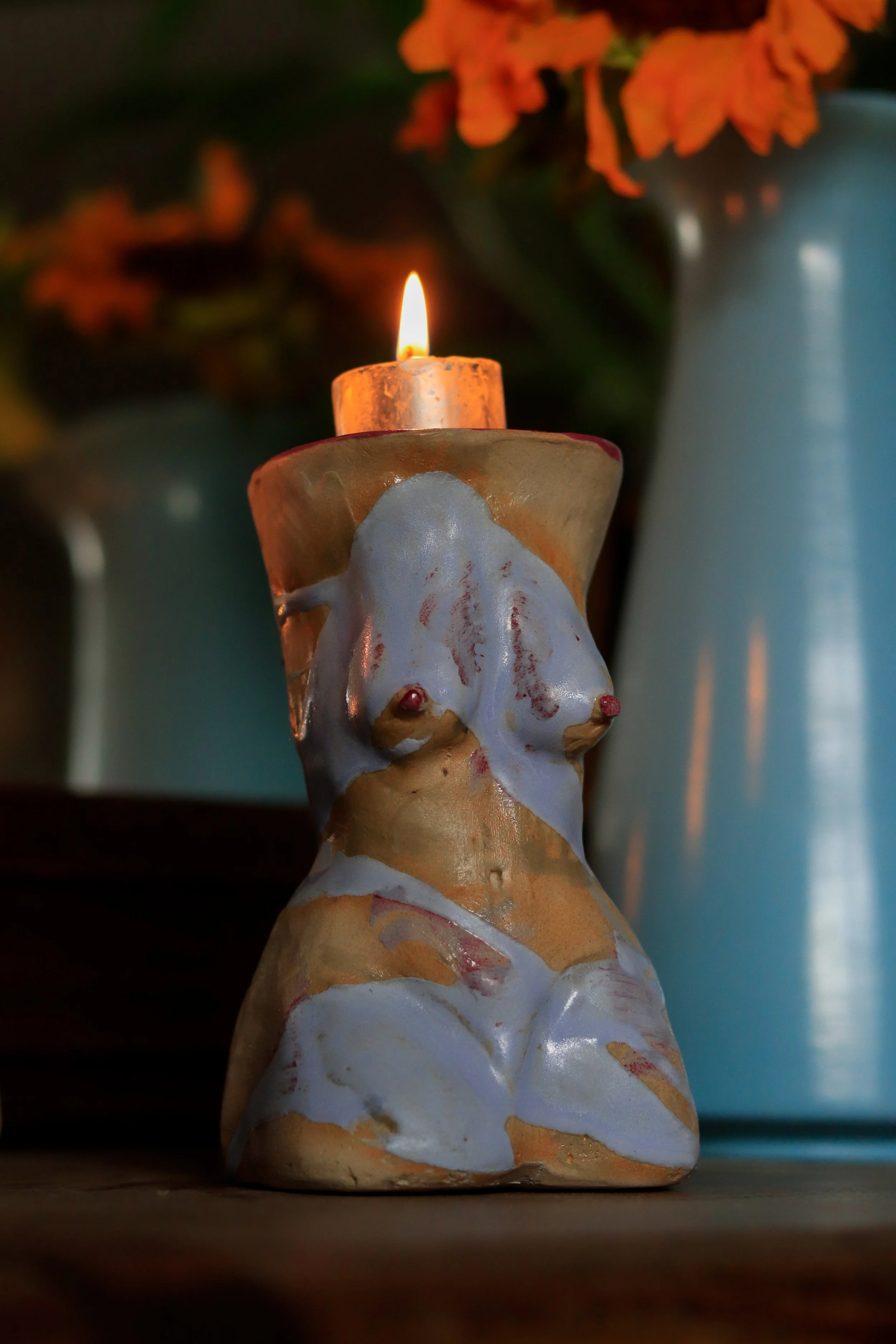 Sculptural ceramic candleholder inspired by the female figure, highlighting light blue brushtroke of glaze and handcrafted ceramic textures.