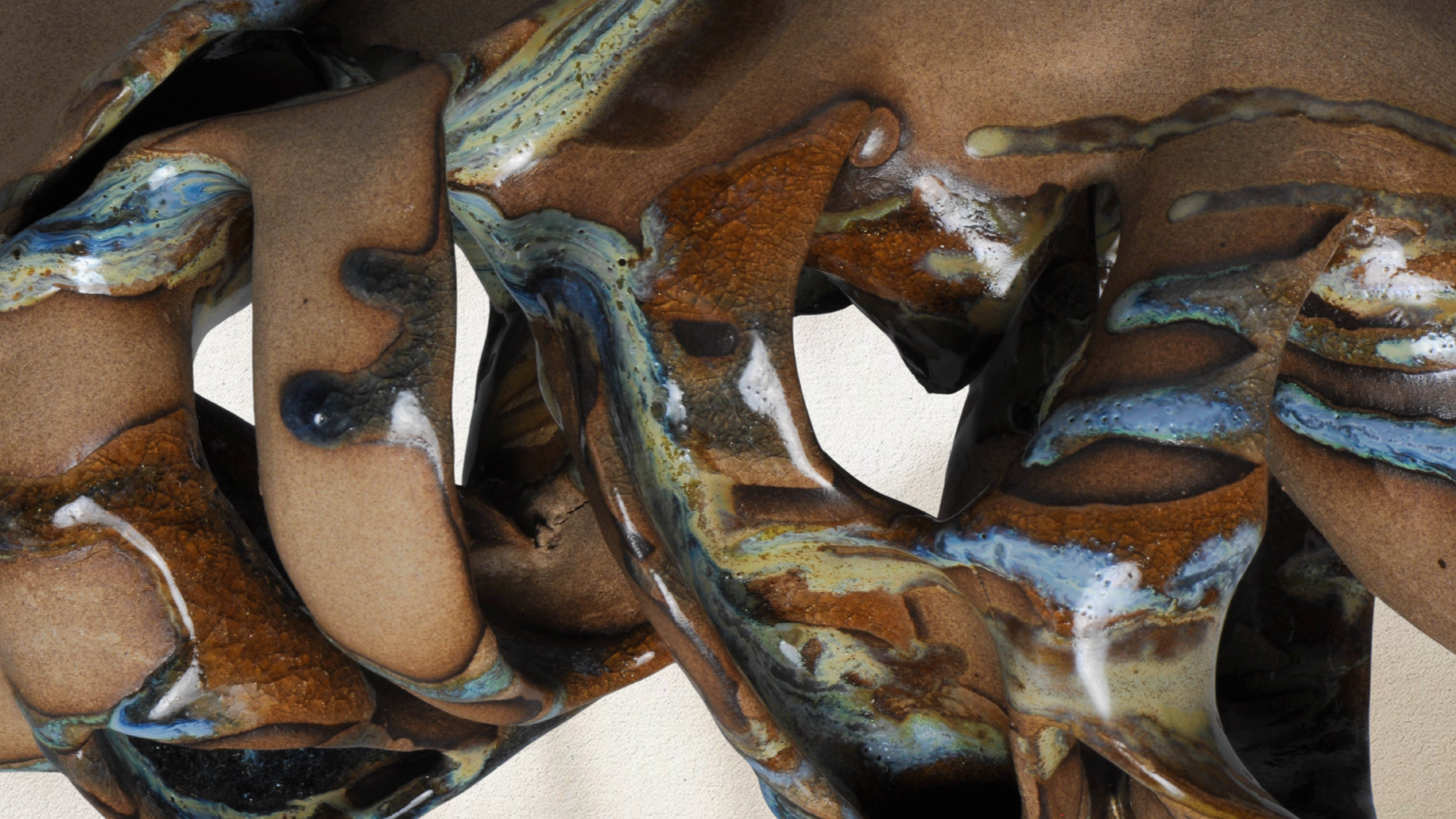 Detail of a hand-built ceramic sculpture featuring curved organic forms, handcrafted textures, and personally formulated ceramic glazes in varied colors.