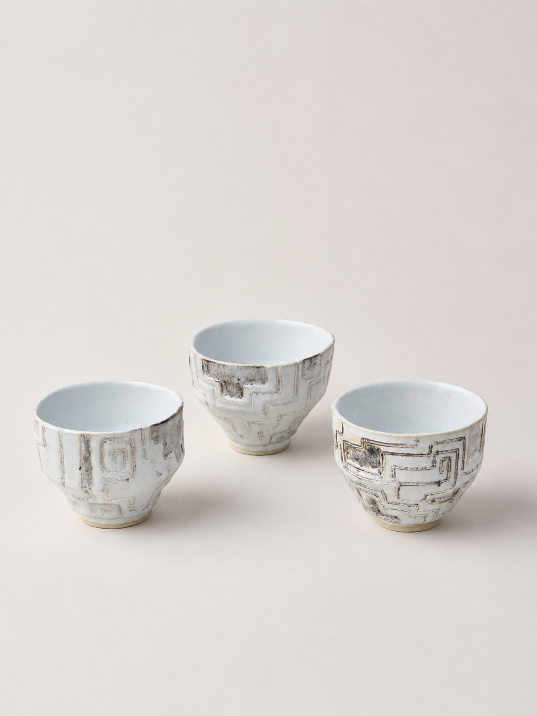 Three hand-built ceramic matcha cups with carved kené-inspired patterns, inspired by the peruvian amazon, created as a private commission.