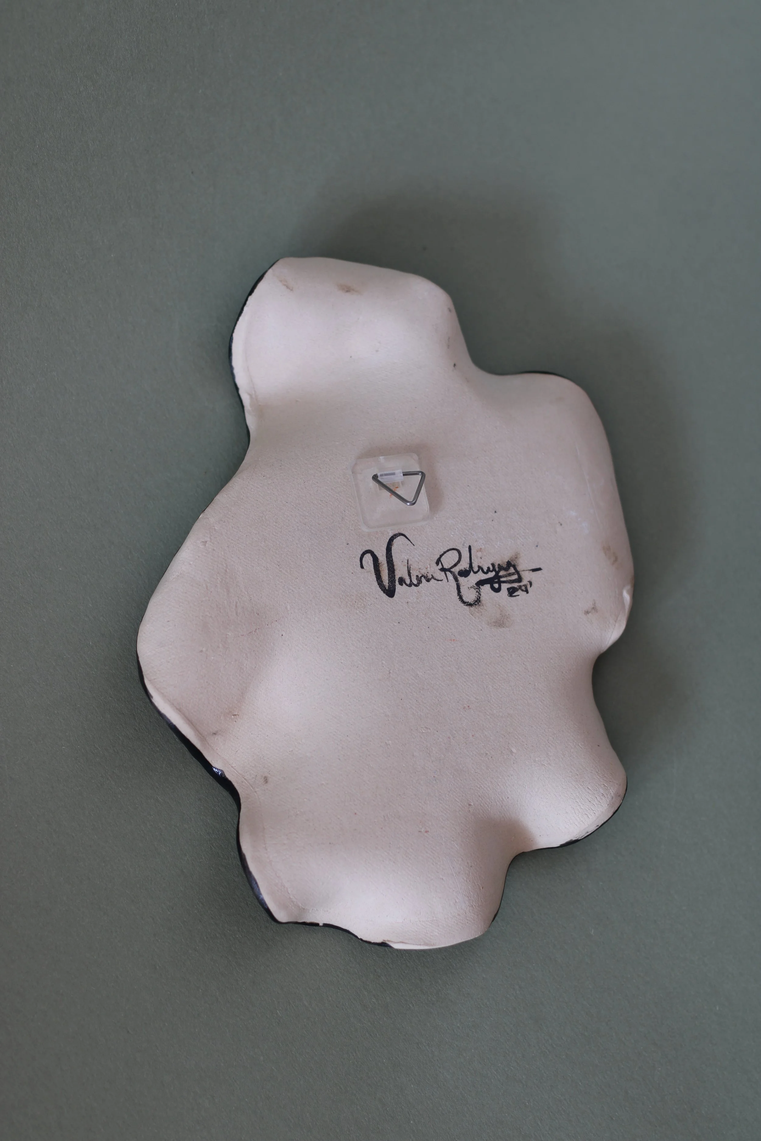 Back view of a hand-built ceramic plate showing its handcrafted ceramic surface and form.
