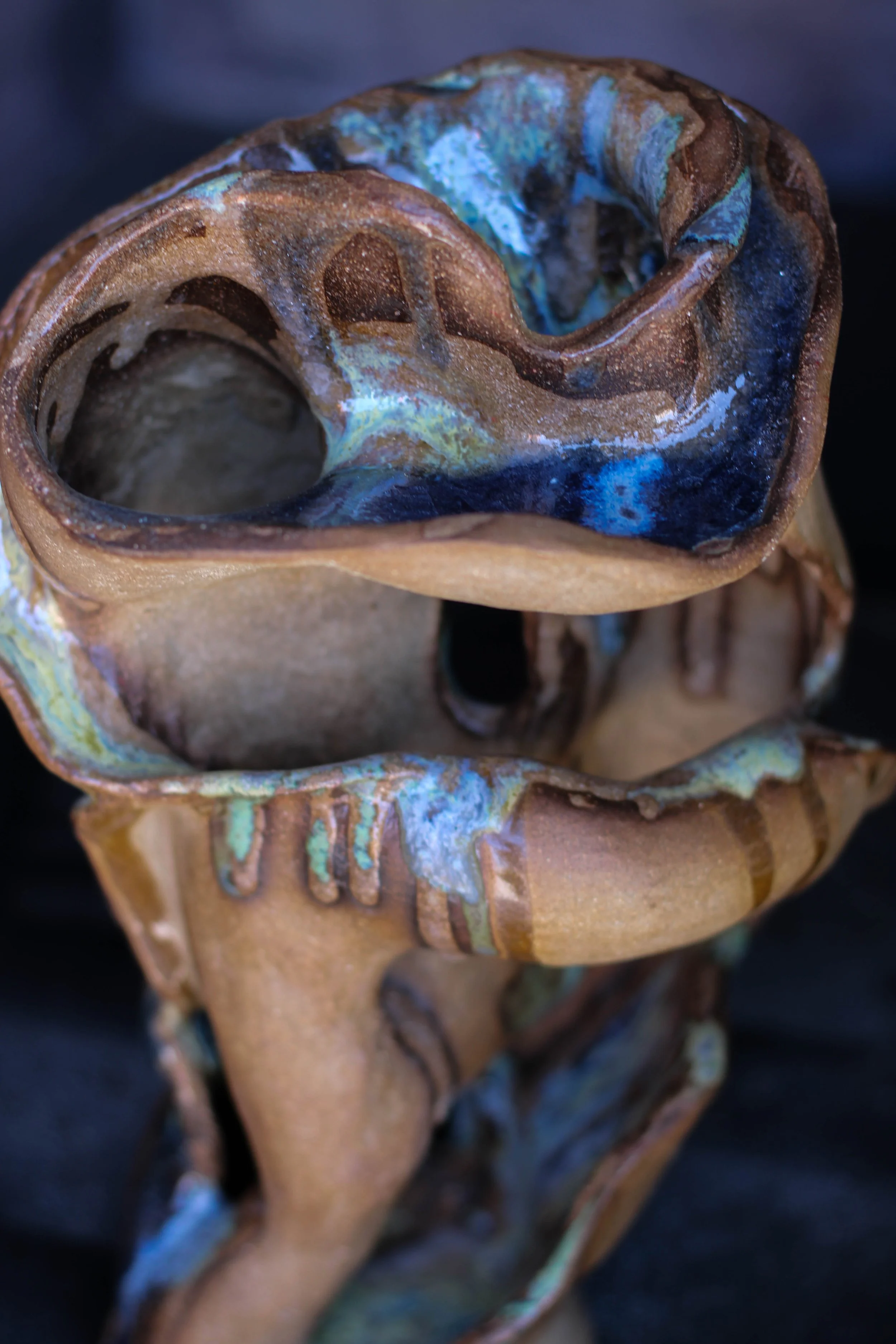 view of a hand-built ceramic vessel showing its fluid sculptural form and layered ceramic surface.
