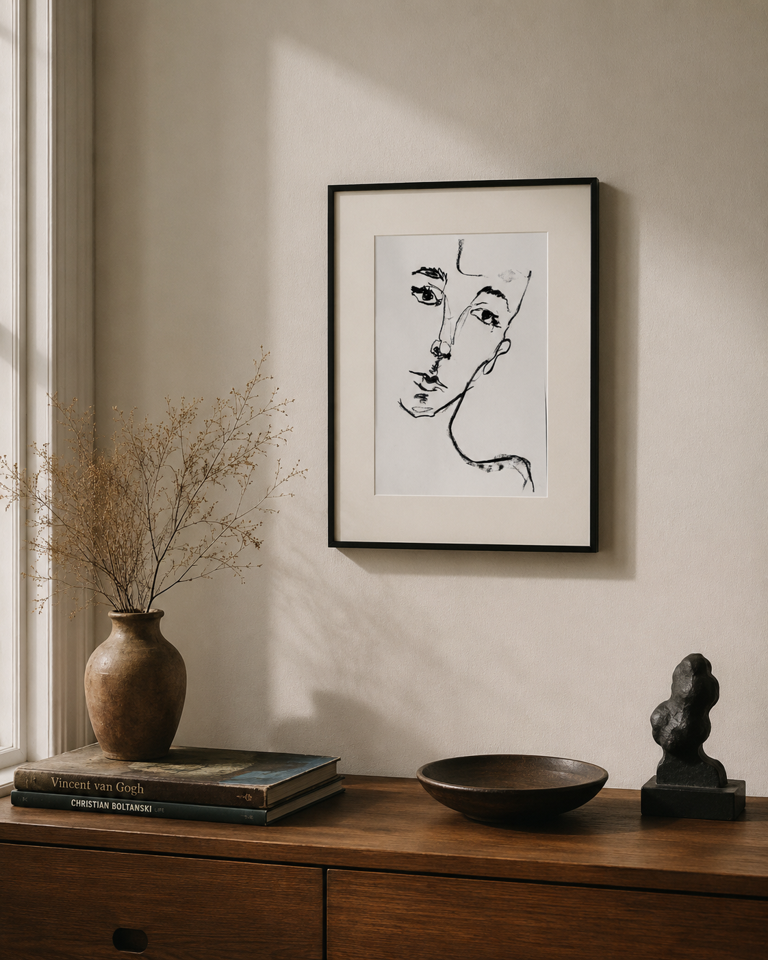 Framed linework portrait by Valeria R.O. displayed in an interior setting, depicting a human face through fluid black gestural lines.