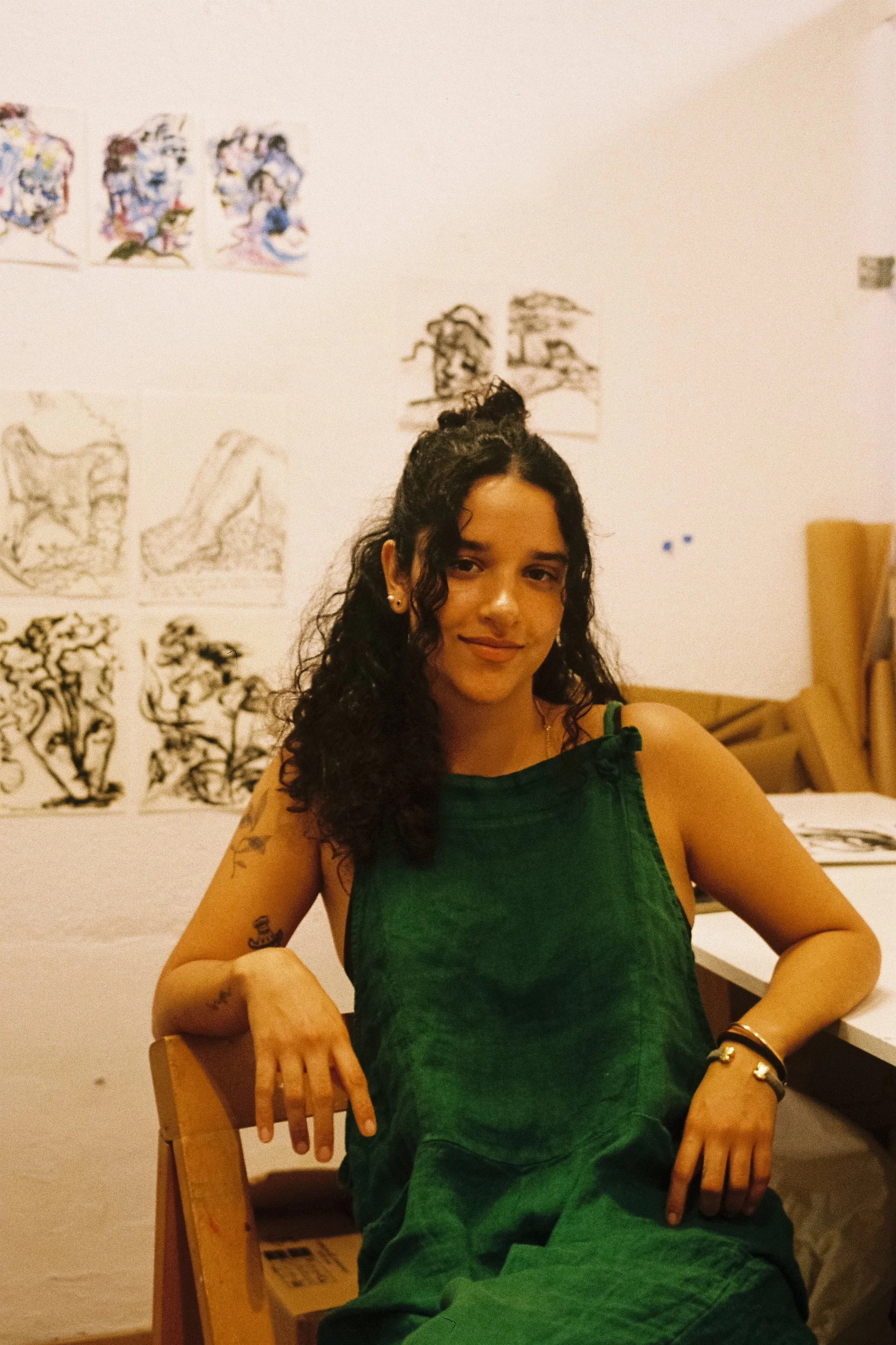 Studio portrait of ceramic artist Valeria R.O. in her workspace, surrounded by her drawings, ceramic sculptures and works in progress.