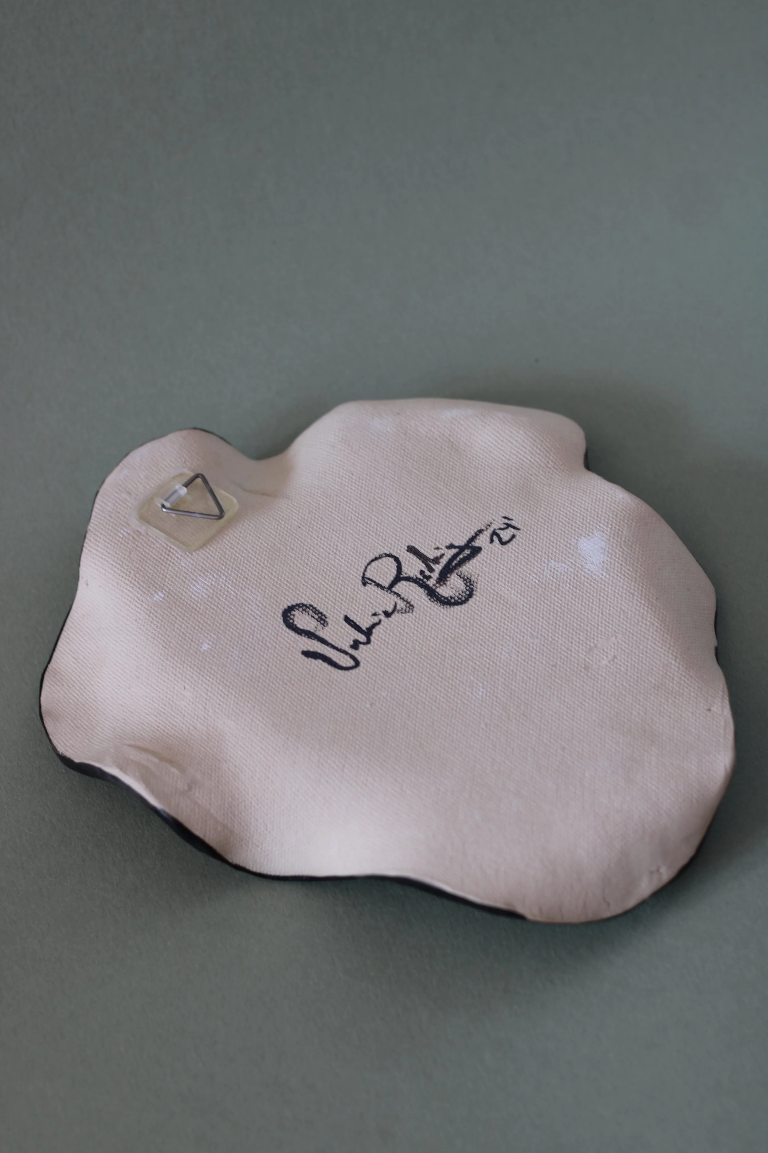 Back view of a hand-built ceramic plate showing its handcrafted ceramic surface and form.