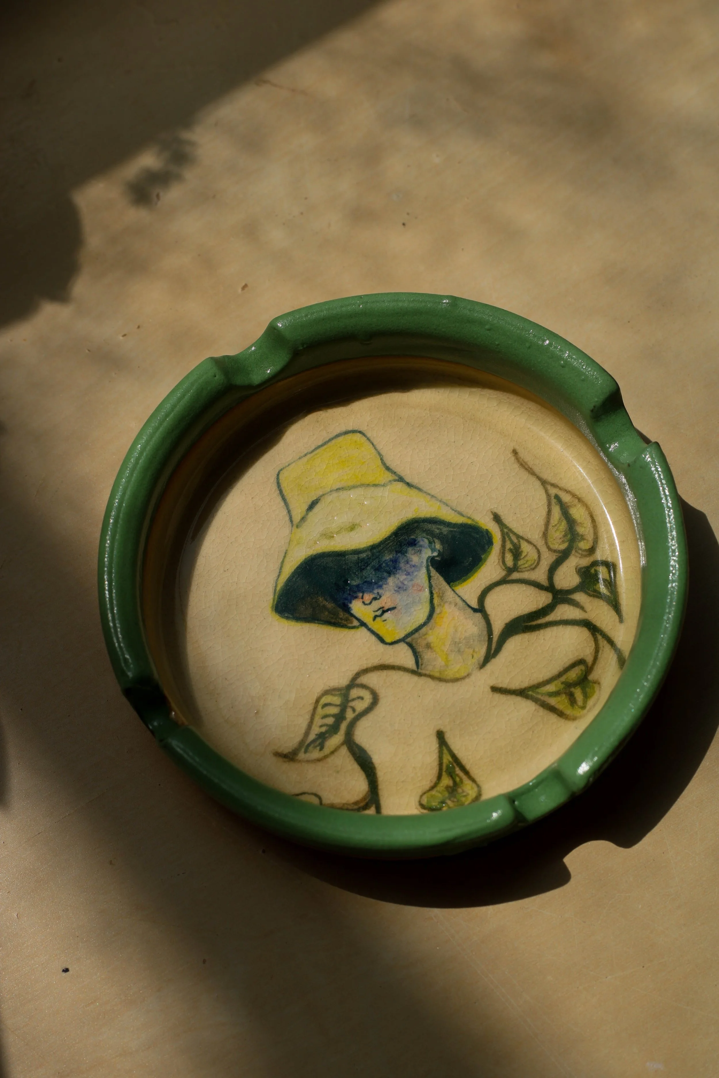 Hand-built illustrated ceramic ashtray featuring an original hand-drawn composition, moss-green glazed edges and layered custom ceramic glazes.