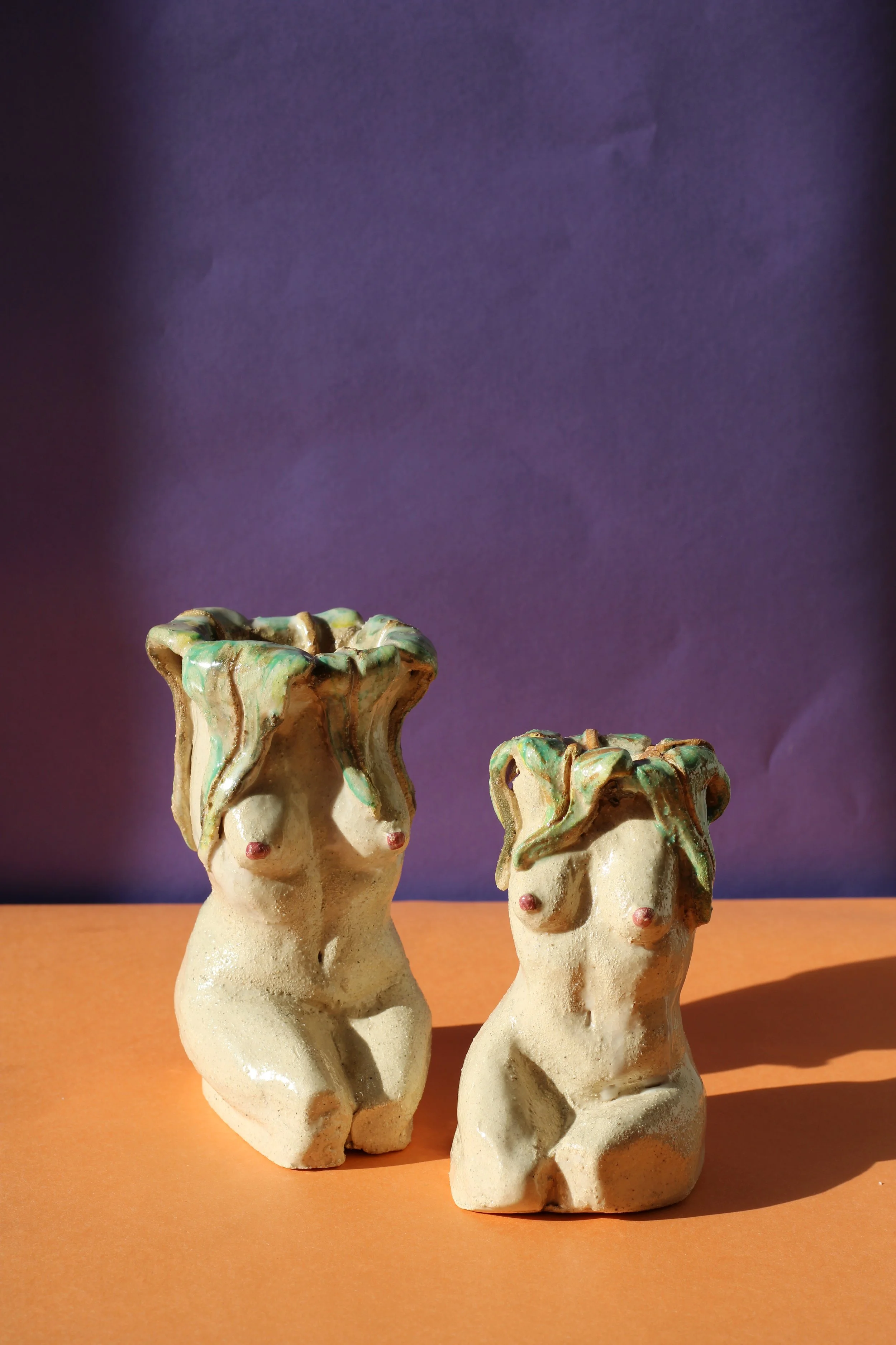 Ceramic candleholder inspired by the female figure, featuring sculped botanical illustrations, blooming plants and flowing botanical forms.