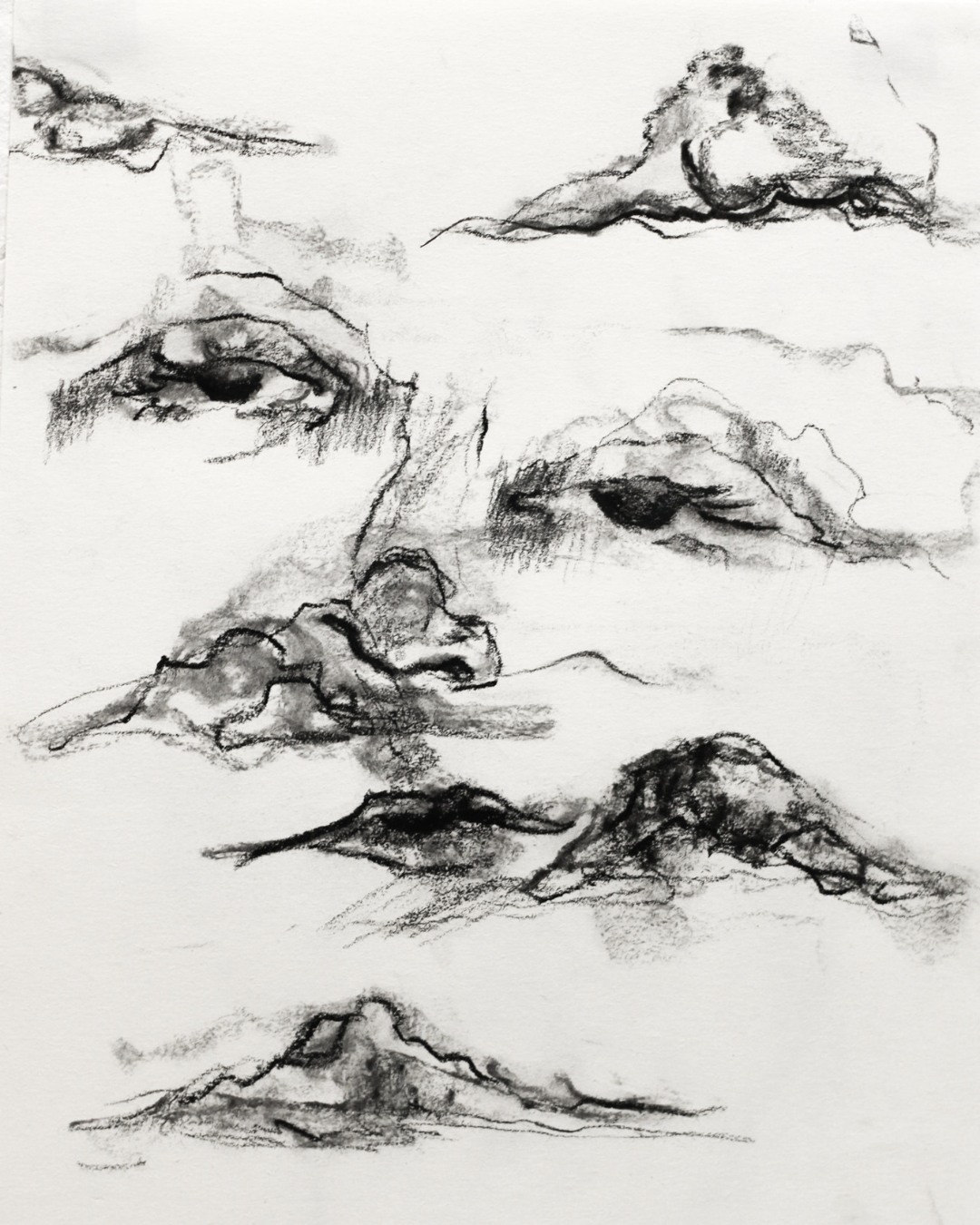 Charcoal drawing depicting flowing landscape-like forms, faces and cloud-like shapes created with expressive charcoal lines and soft tonal shading