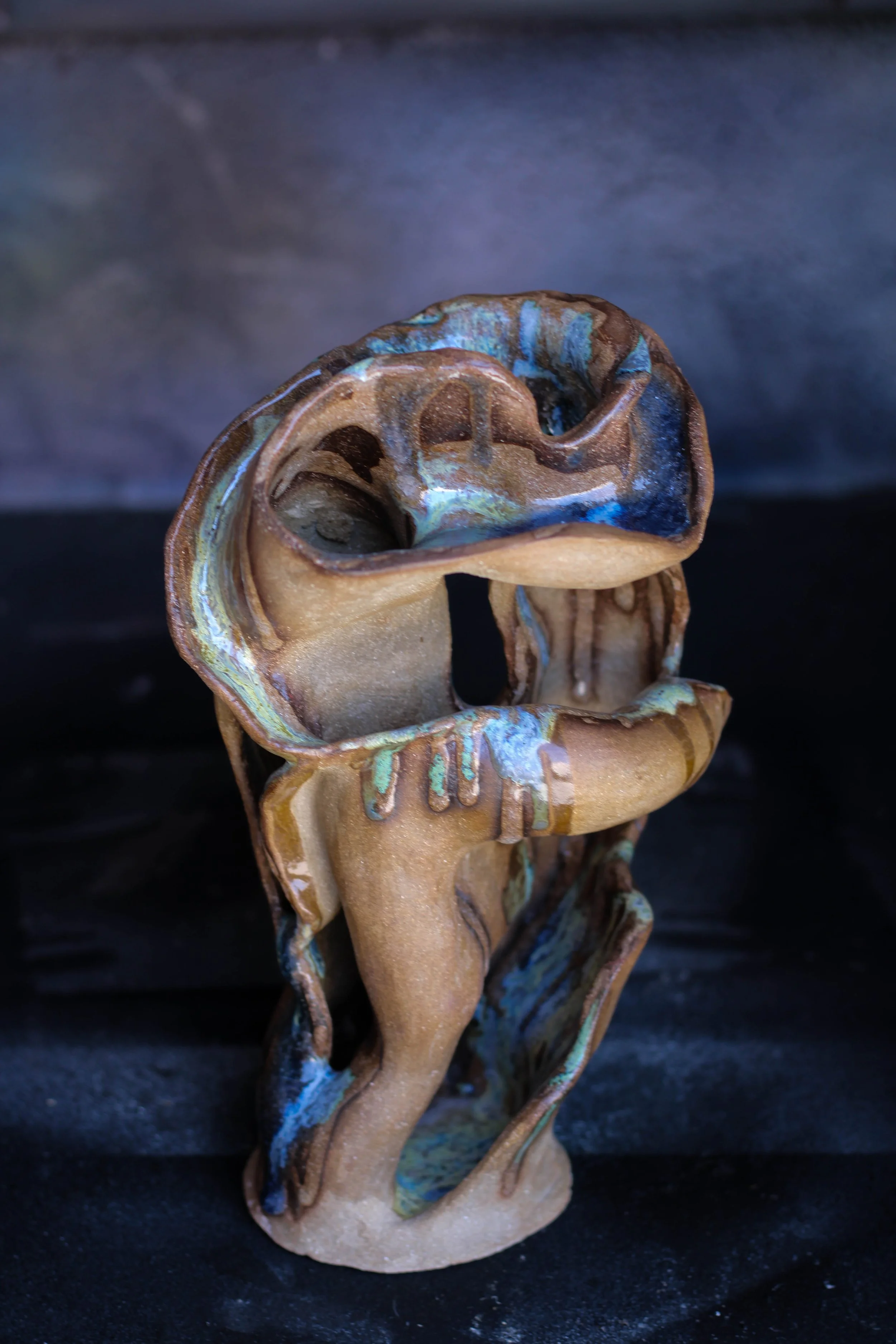 Detail of the fluid sculptural curves, layered openings and hand-finished ceramic surface.