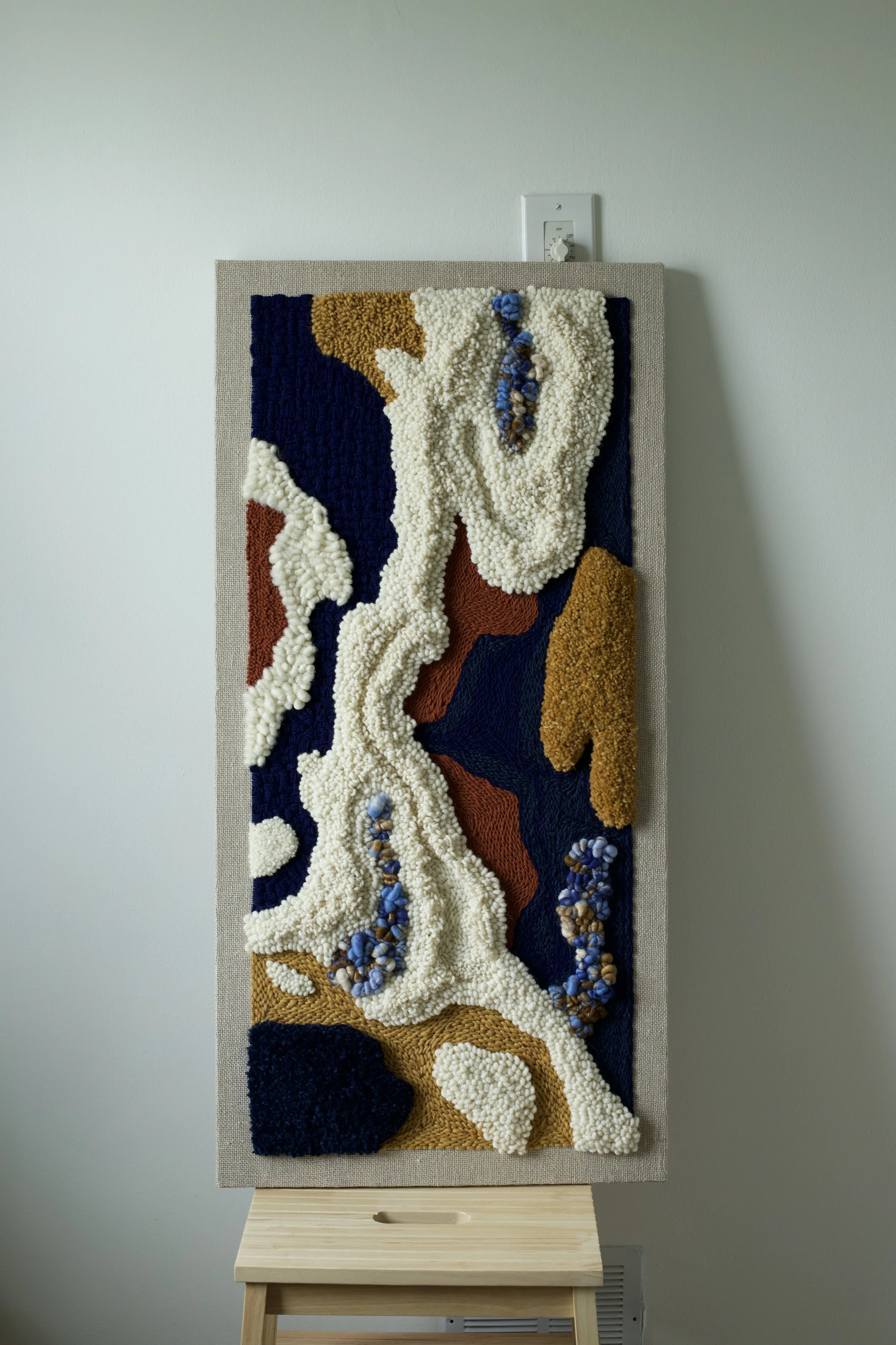 Thandiwe (beloved) made 2025

“Thandiwe” is a textured fiber artwork that speaks to tenderness, memory and connection. this piece weaves together layers of natural fibers in shades of ivory, rust, deep navy, and soft blue. The organic shapes and tact
