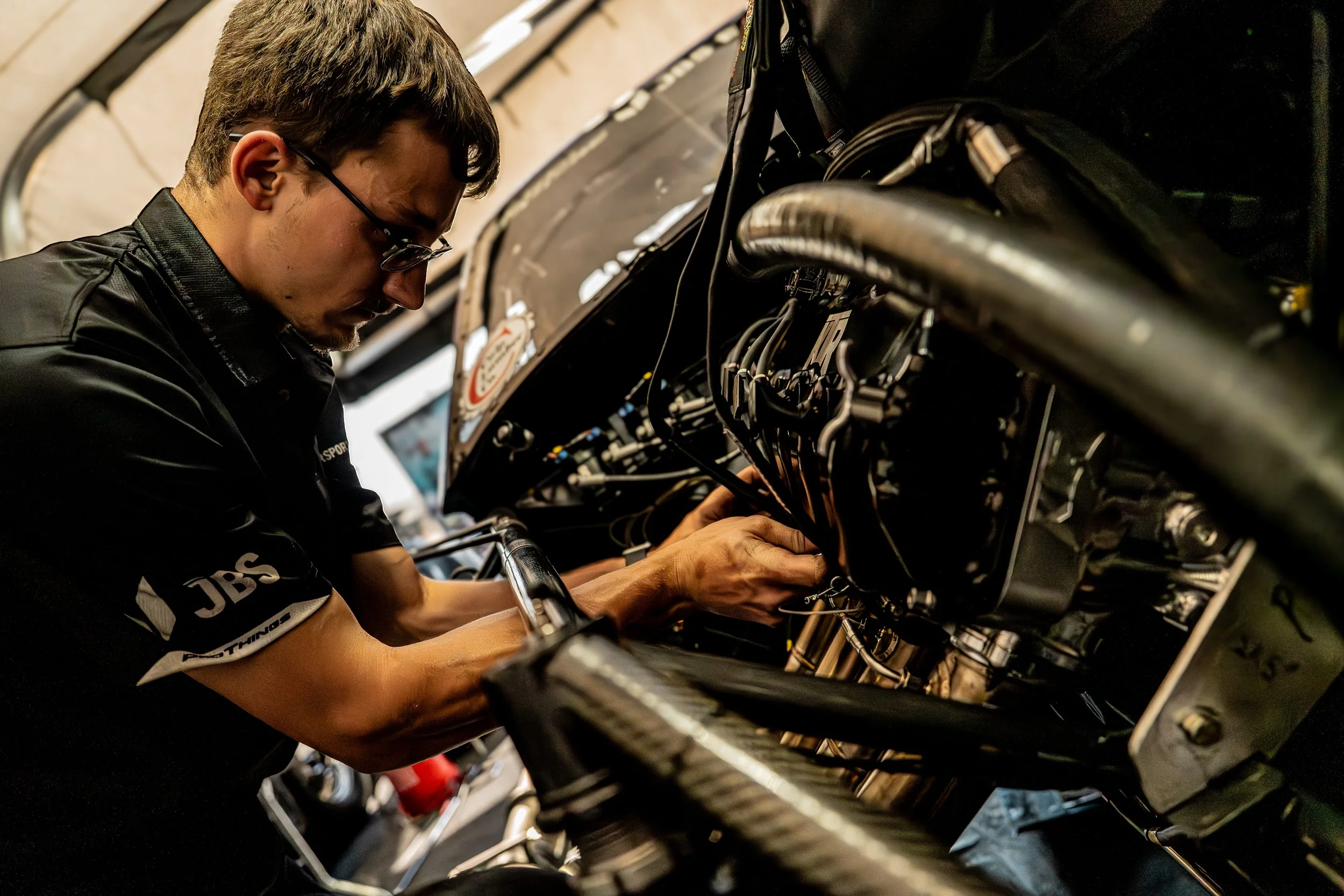 A person working on a mechanical or electronic device with wires.