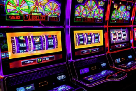 Close-up of slot machines with colorful spinning reels in a casino.