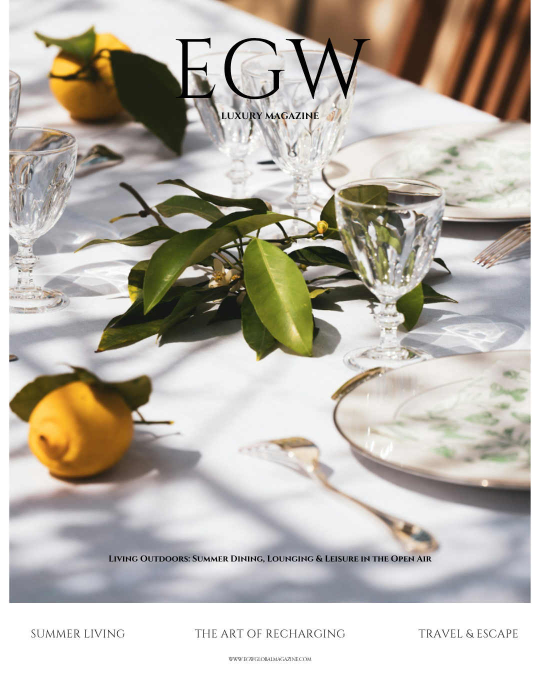 A dining table setup with glassware, plates, and cutlery decorated with greenery and lemons.