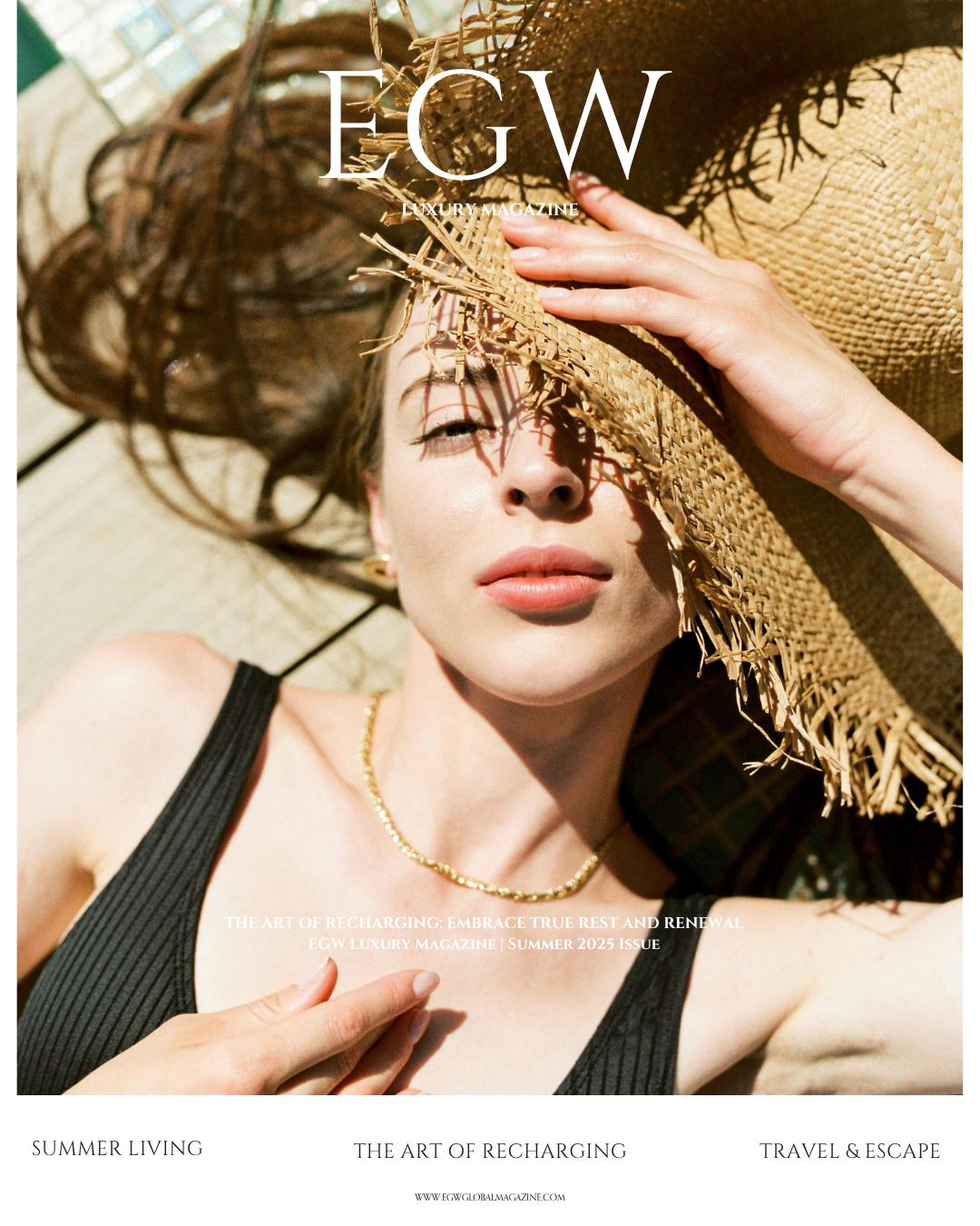 Cover of EGW Luxury Magazine featuring a woman lying on the ground, wearing a large straw hat, black sleeveless top, gold necklace, with sunlight casting shadows on her face.