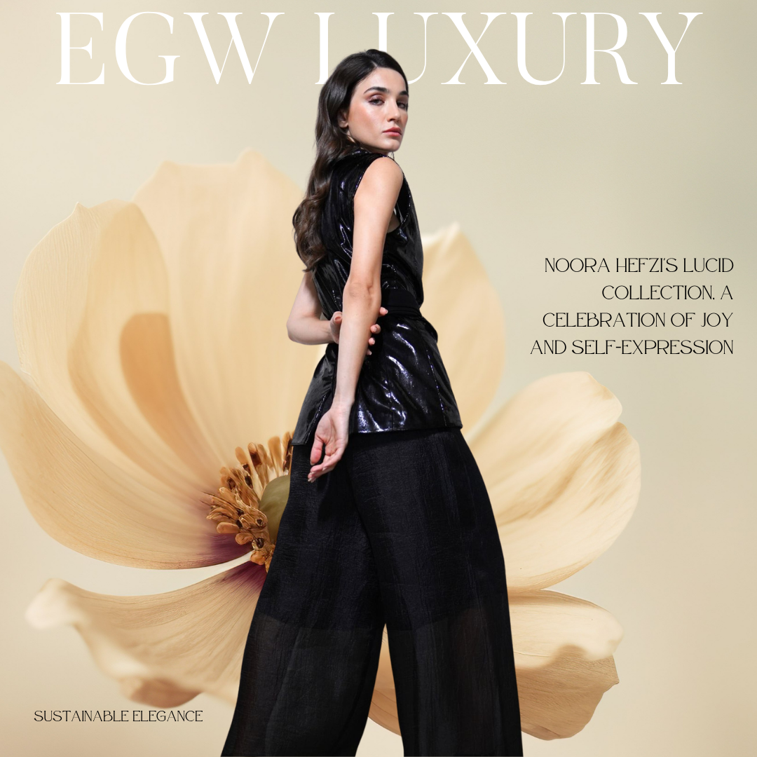 Fashion magazine cover featuring a woman in black shiny clothing standing in front of a large beige flower. The cover text reads: "EGW LUXURY" at the top, and "NOORA HEFZI'S LUCID COLLECTION. A CELEBRATION OF JOY AND SELF-EXPRESSION" to the right of 
