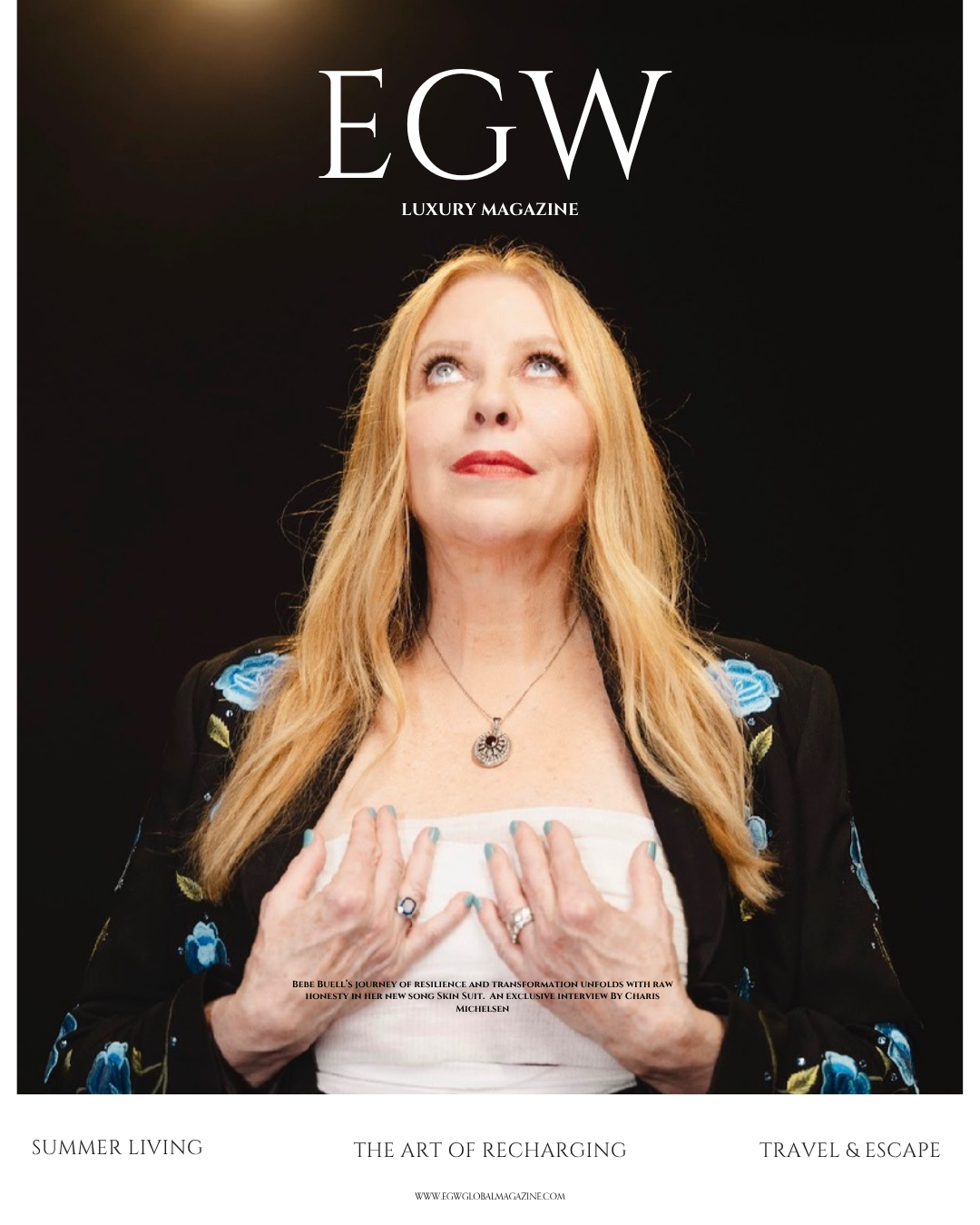 Cover of EGW luxury magazine featuring a woman with long blonde hair wearing a black jacket with blue flower embroidery, a white top, and jewelry, looking upward with her hands on her chest against a dark background.