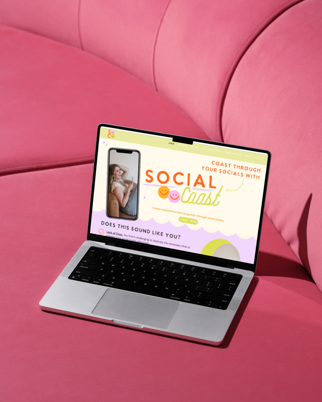Laptop on a pink couch screen displays a website titled 'Social Cast' with a woman using a phone, colorful text and smiley faces.
