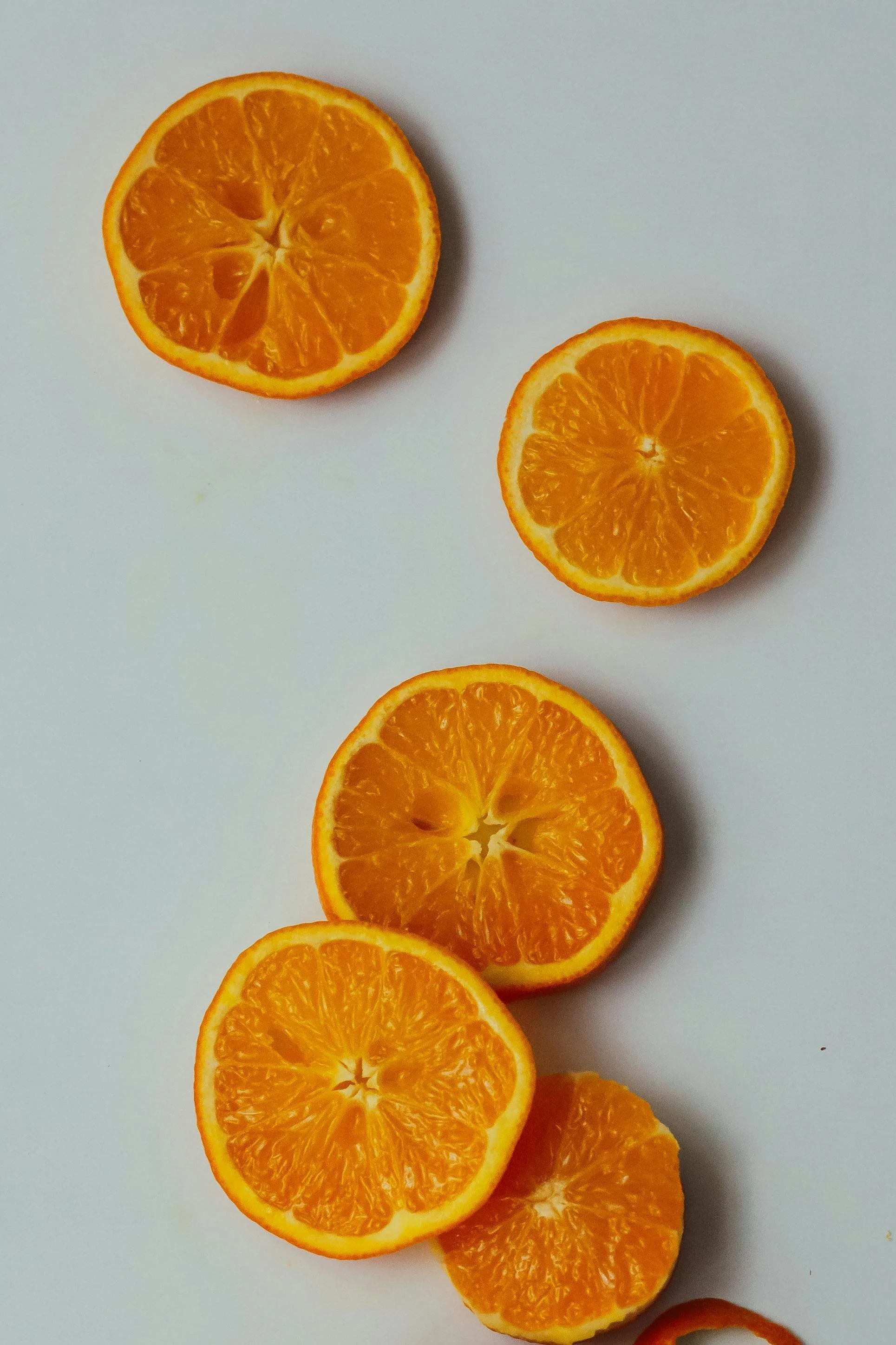 Multiple orange citrus slices arranged on a white background.
