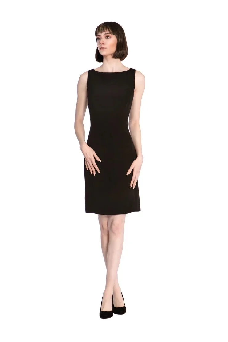 A woman in a sleeveless black dress and black heels, standing with one hand on her hip against a white background.