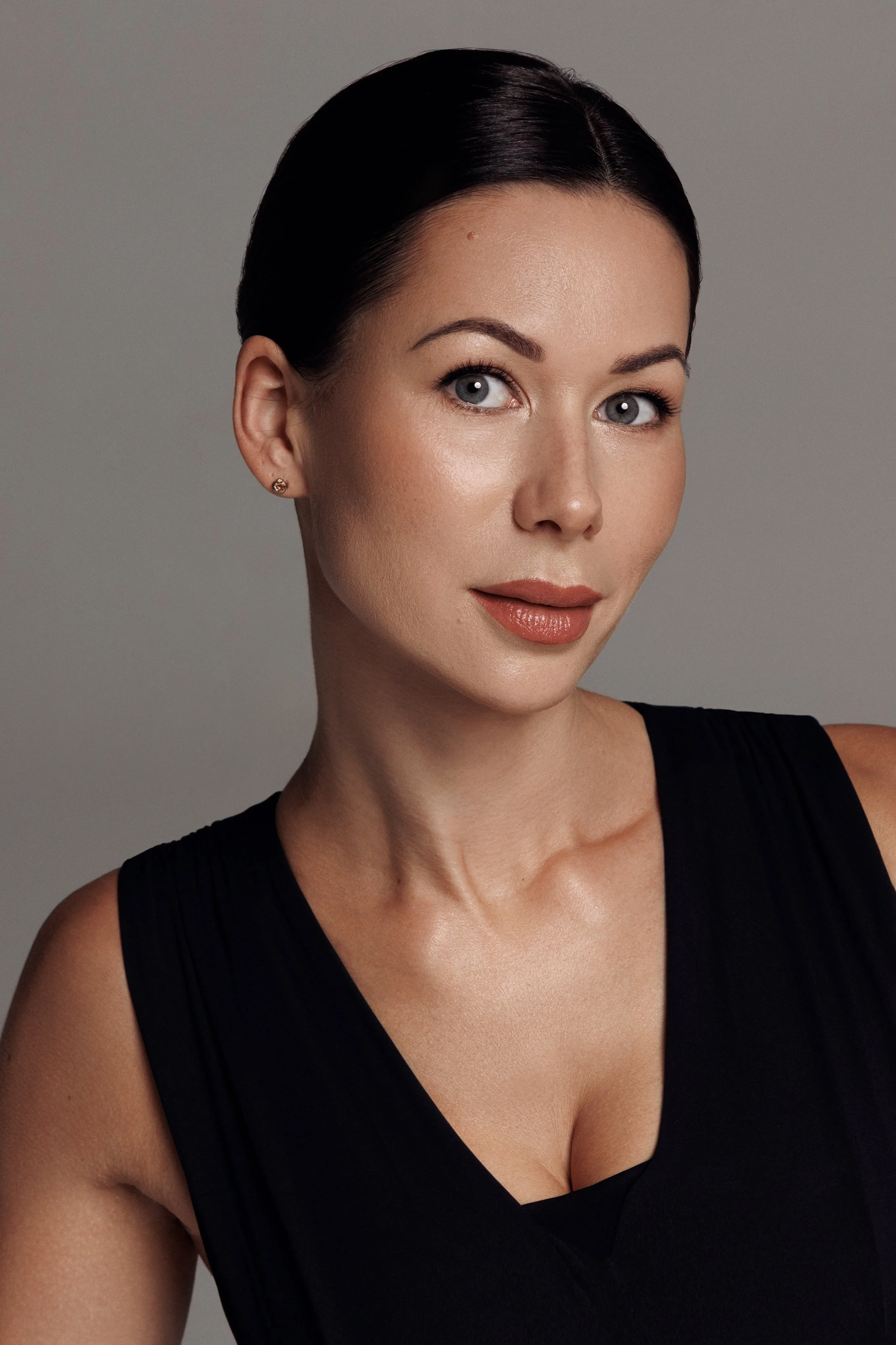 Close-up portrait of Ketija wearing a black sleeveless top, standing against a neutral background.
