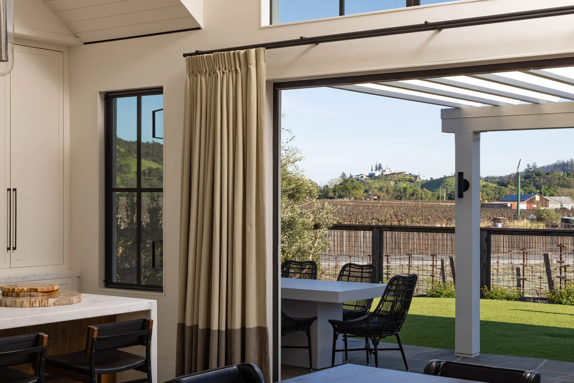Indoor dining area with a view of a backyard patio and landscape outside.
