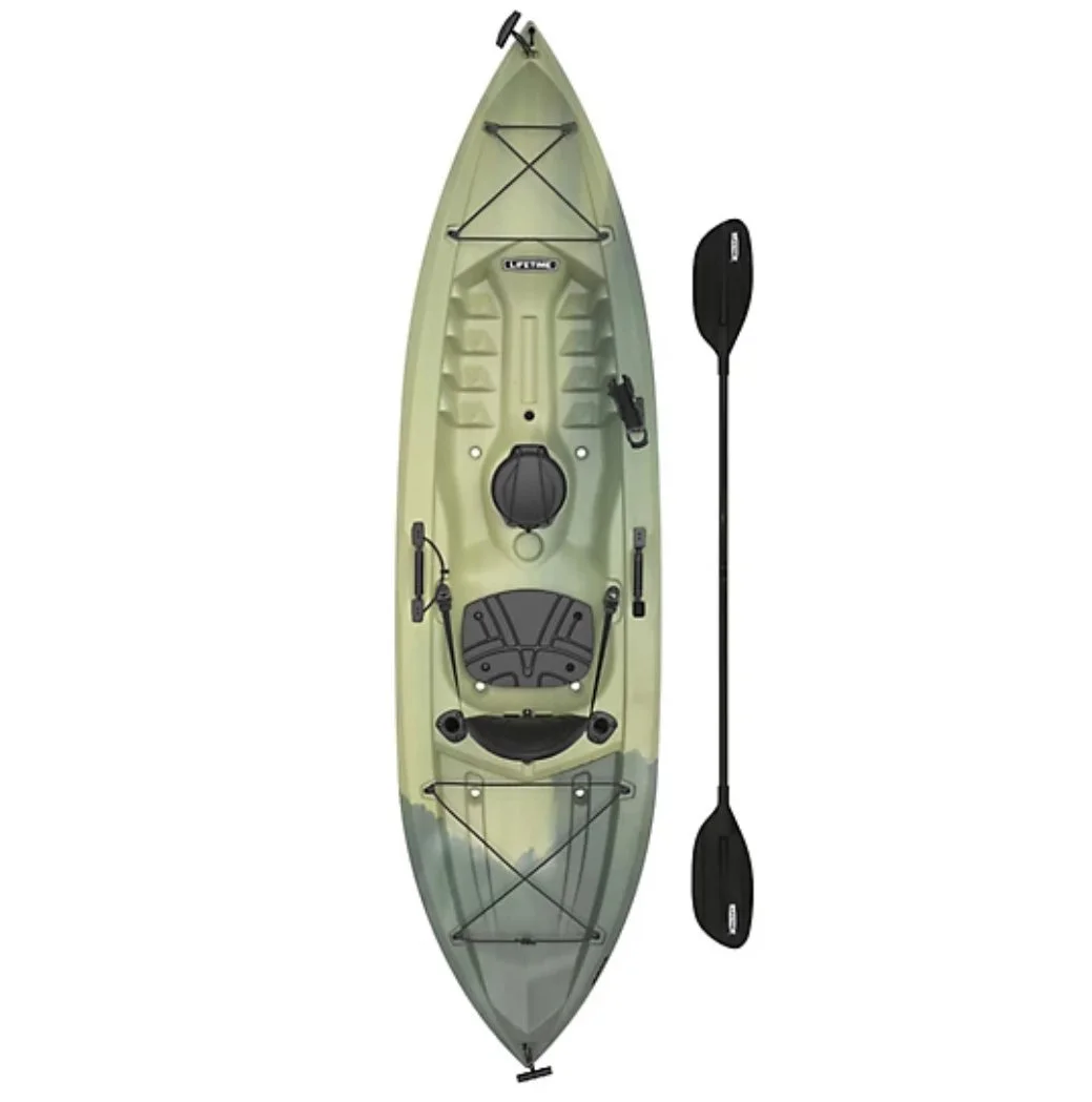 Green kayak with black paddle and various accessories isolated on white background.