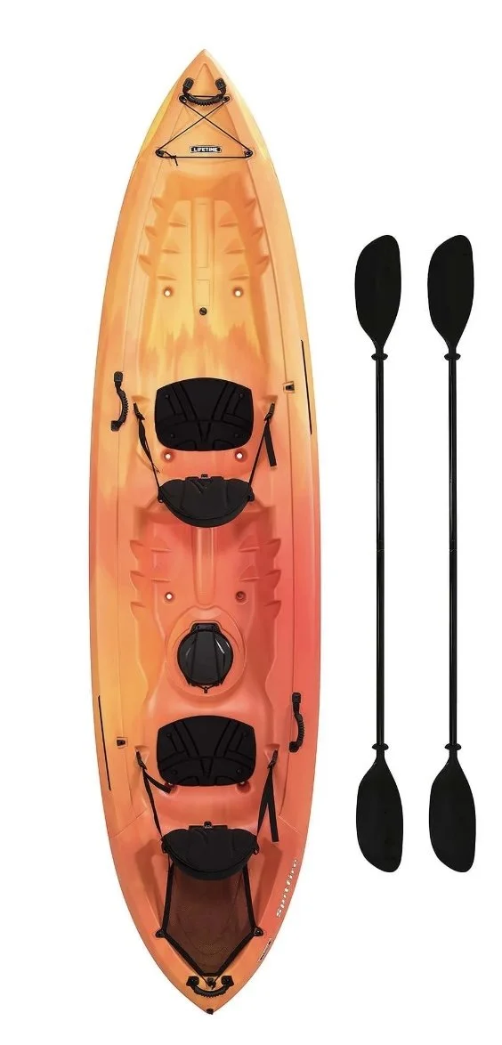 Orange kayak with two black paddles placed beside it.