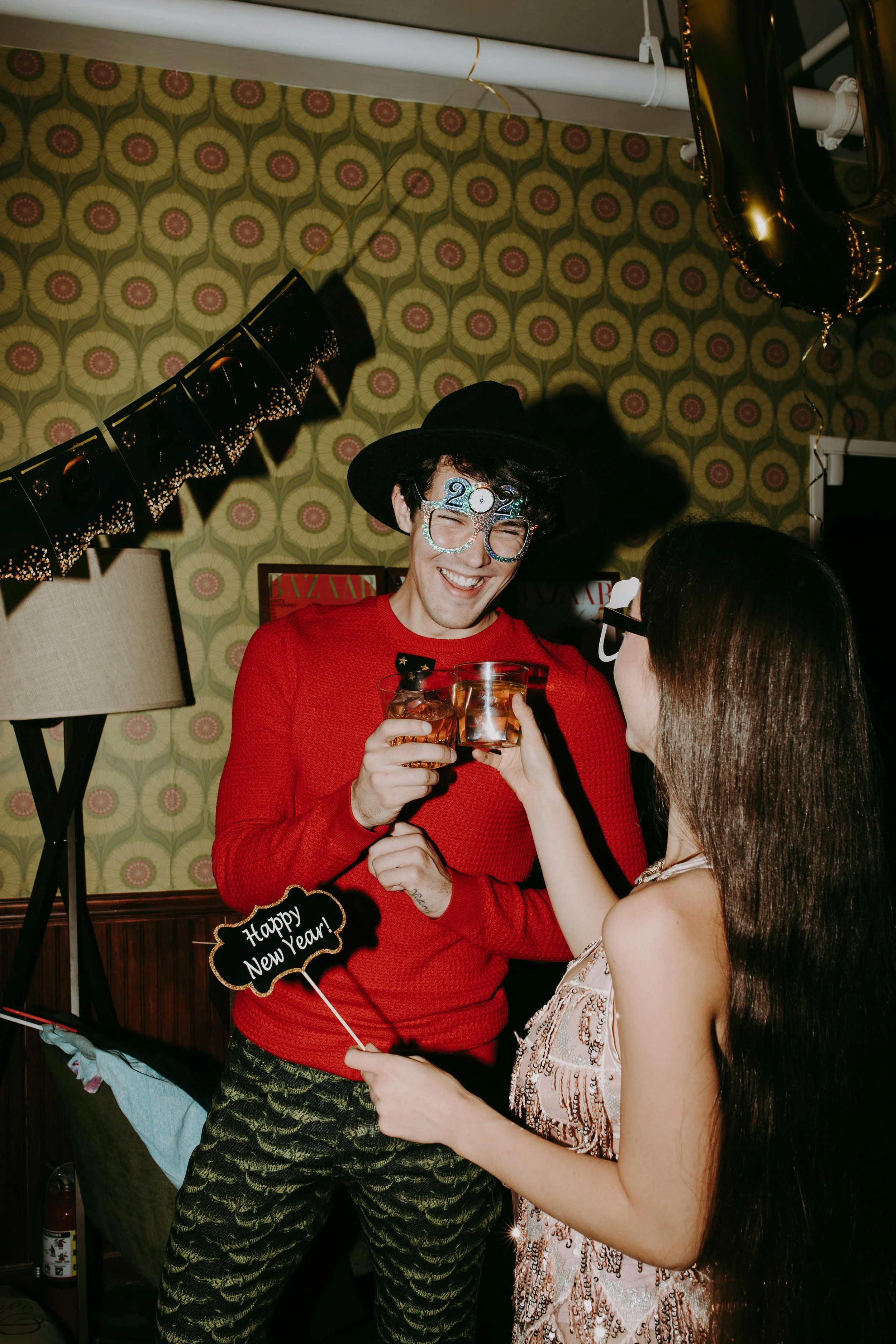 Man and woman at a New Year's Eve party enjoying cocktails.