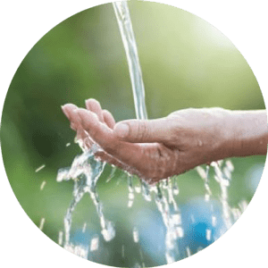 Hand cupping water from a stream outdoors
