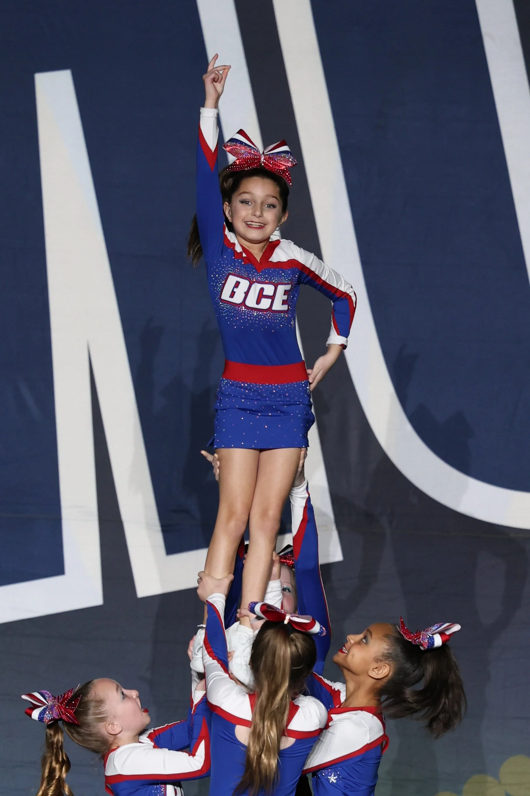 Cheerleaders performing a pyramid routine during a cheerleading competition.