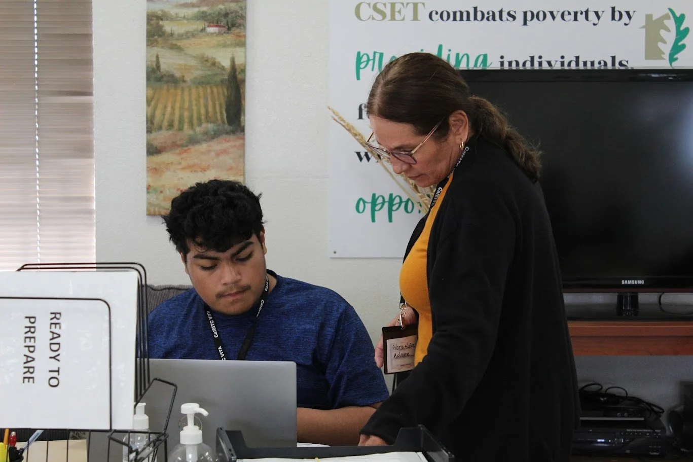 a tax professional instructing a young man doing his taxes