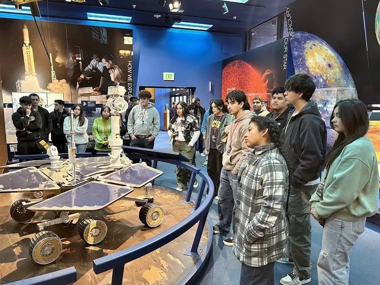a group of teenagers exploring a scene exhibit