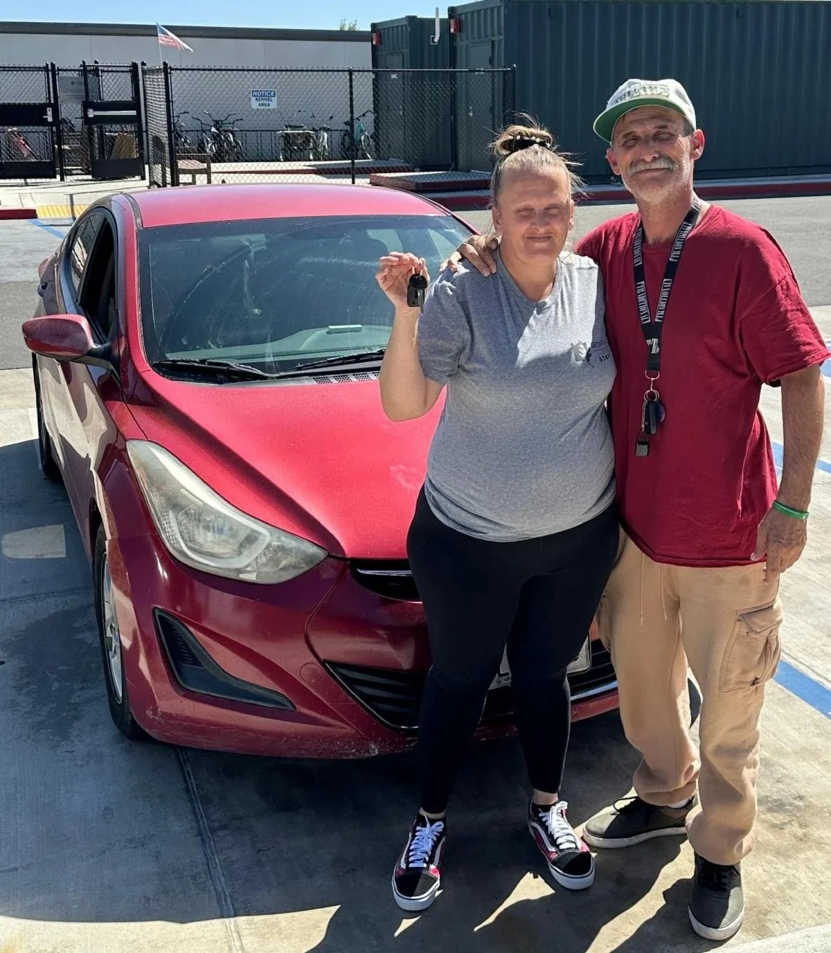 a couple holding car keys to a new car
