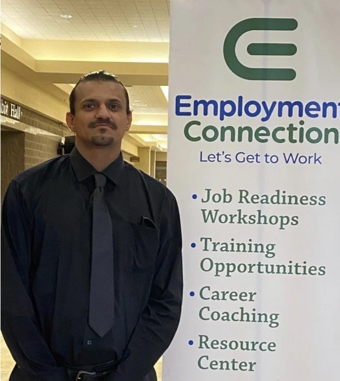 Photo of a man posing with our employment connection sign