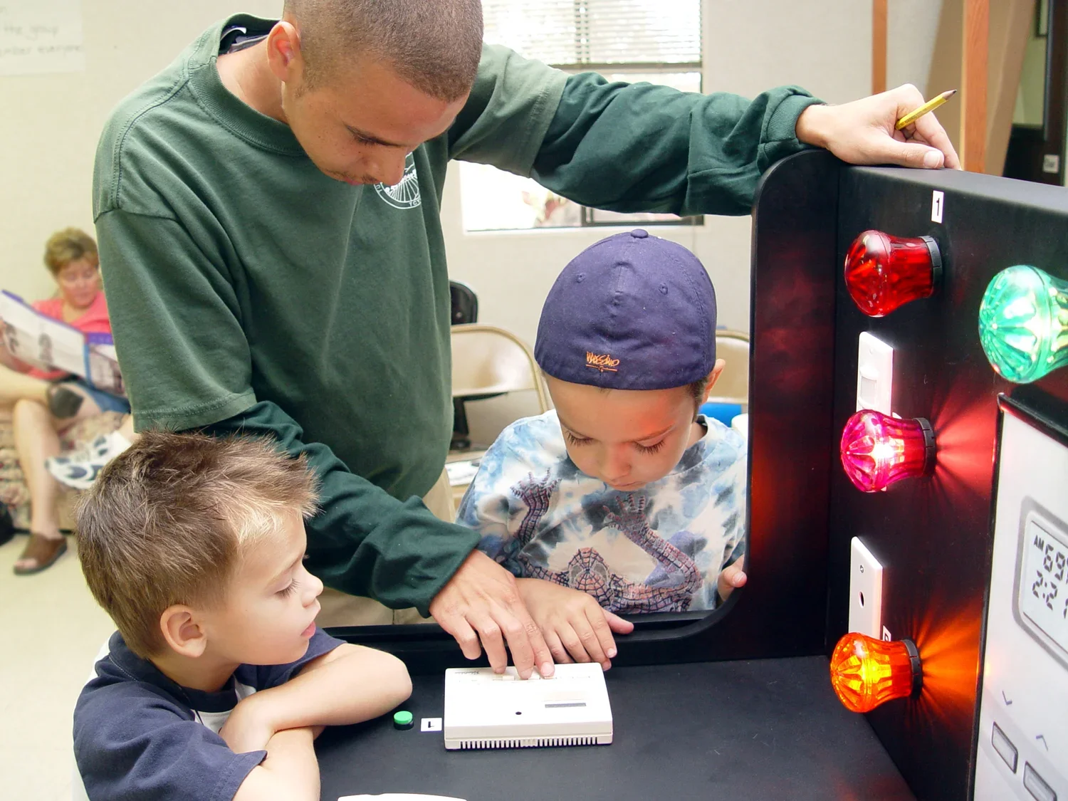 teen boy and two boys looking at a science project