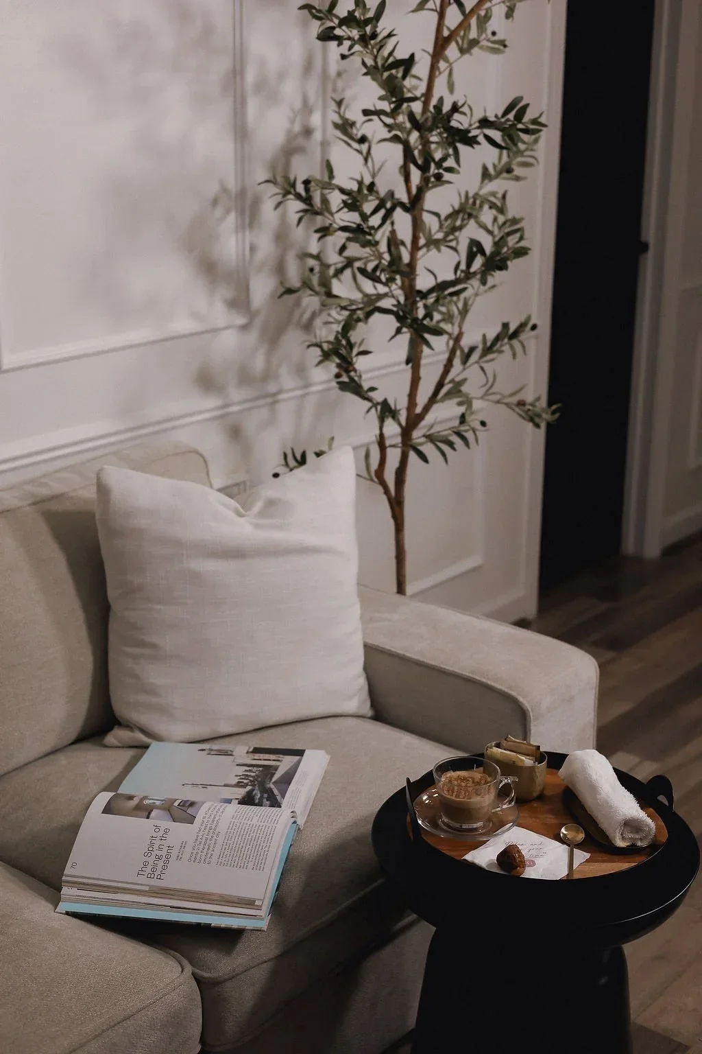 Spa lounge with a beige sofa and refreshments on a side table.