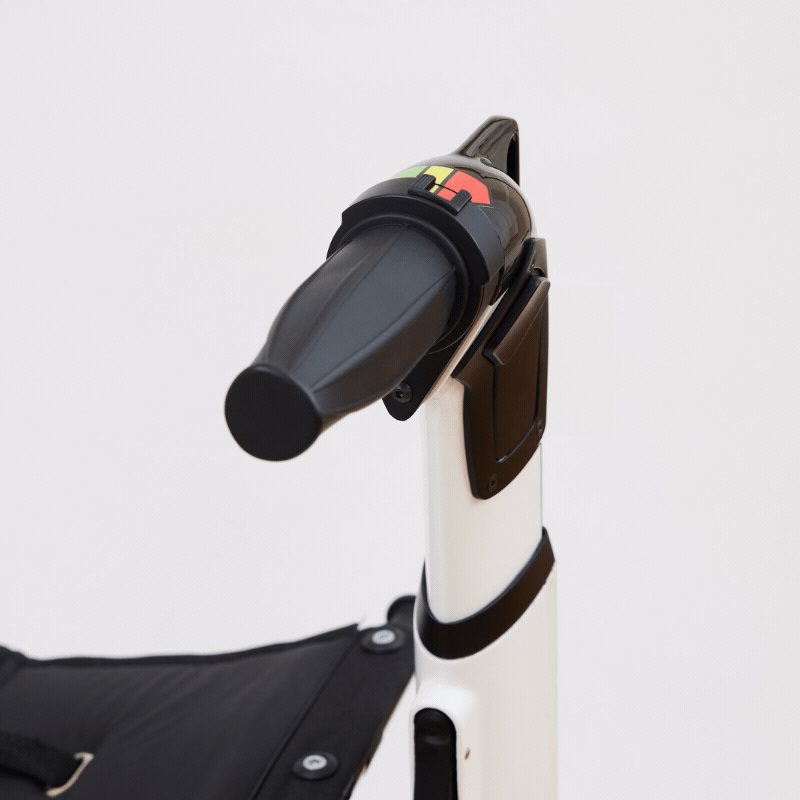 Close-up of the handle and control panel of a stair lift chair with black armrest and safety strap.