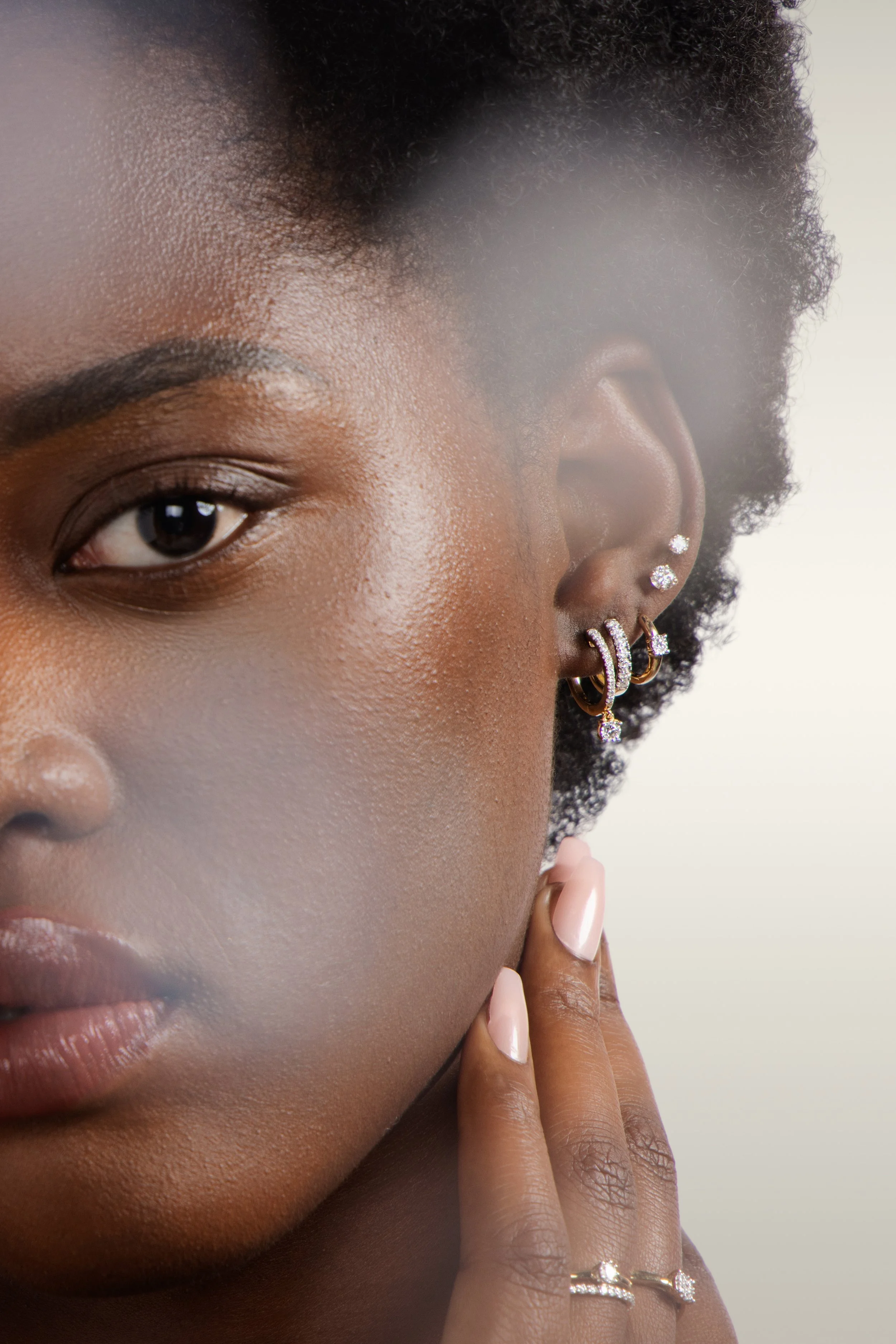 Close-up beauty portrait featuring stacked earrings and jewelry styling for Banter campaign.