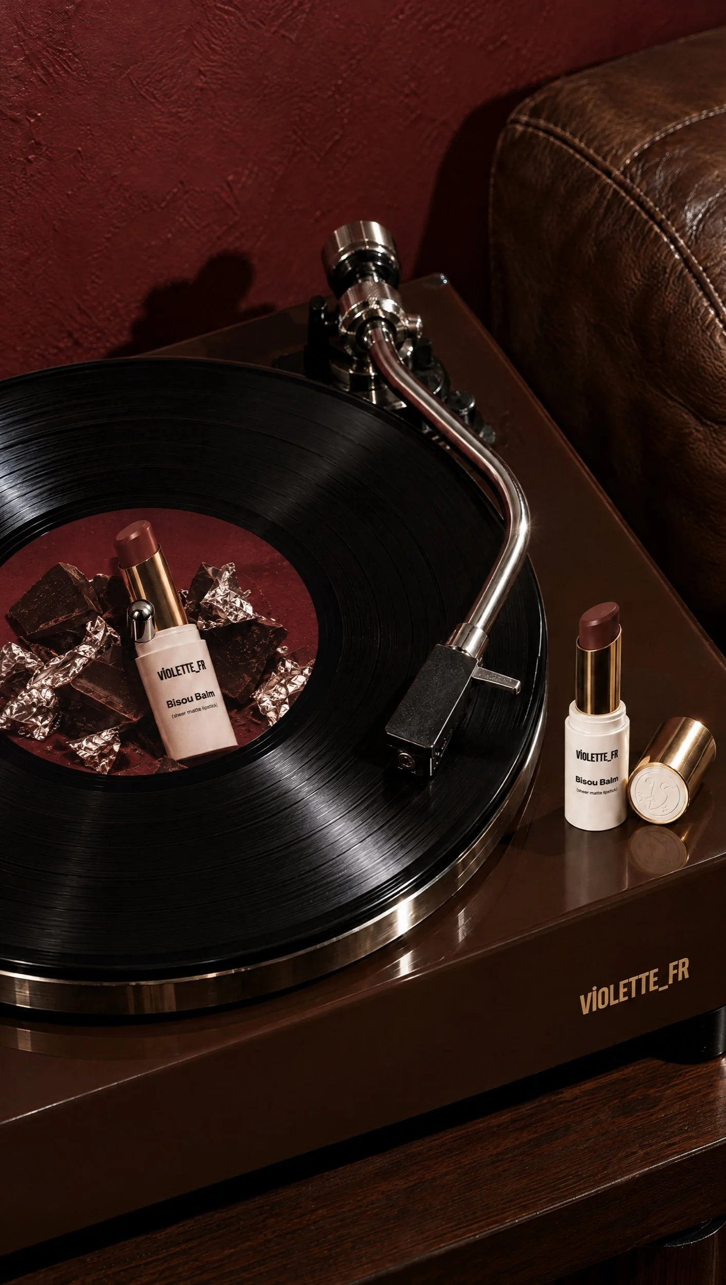 Lipstick on a turntable beside a record