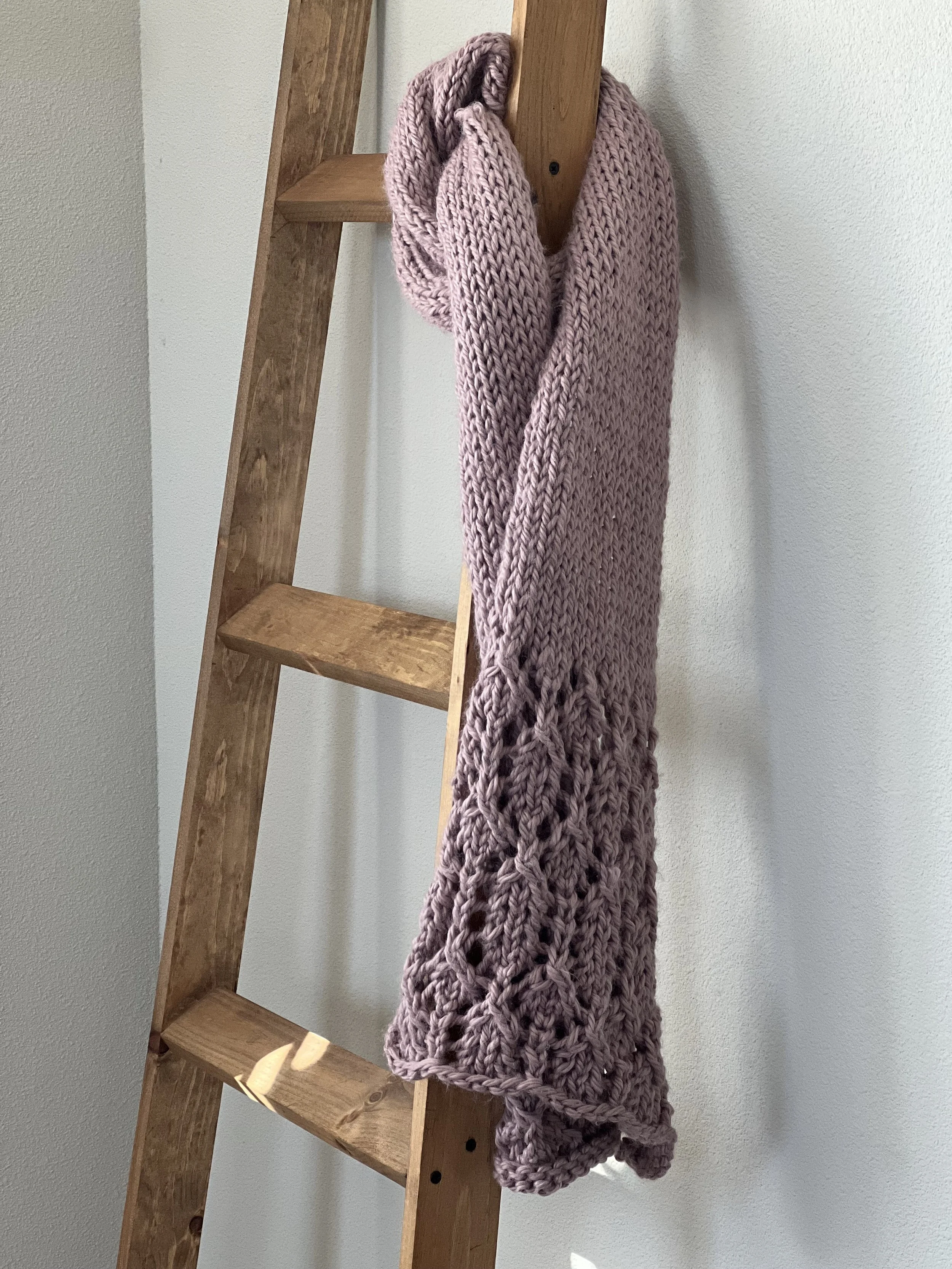 full length bulky knit scarf pattern hanging on wooden ladder