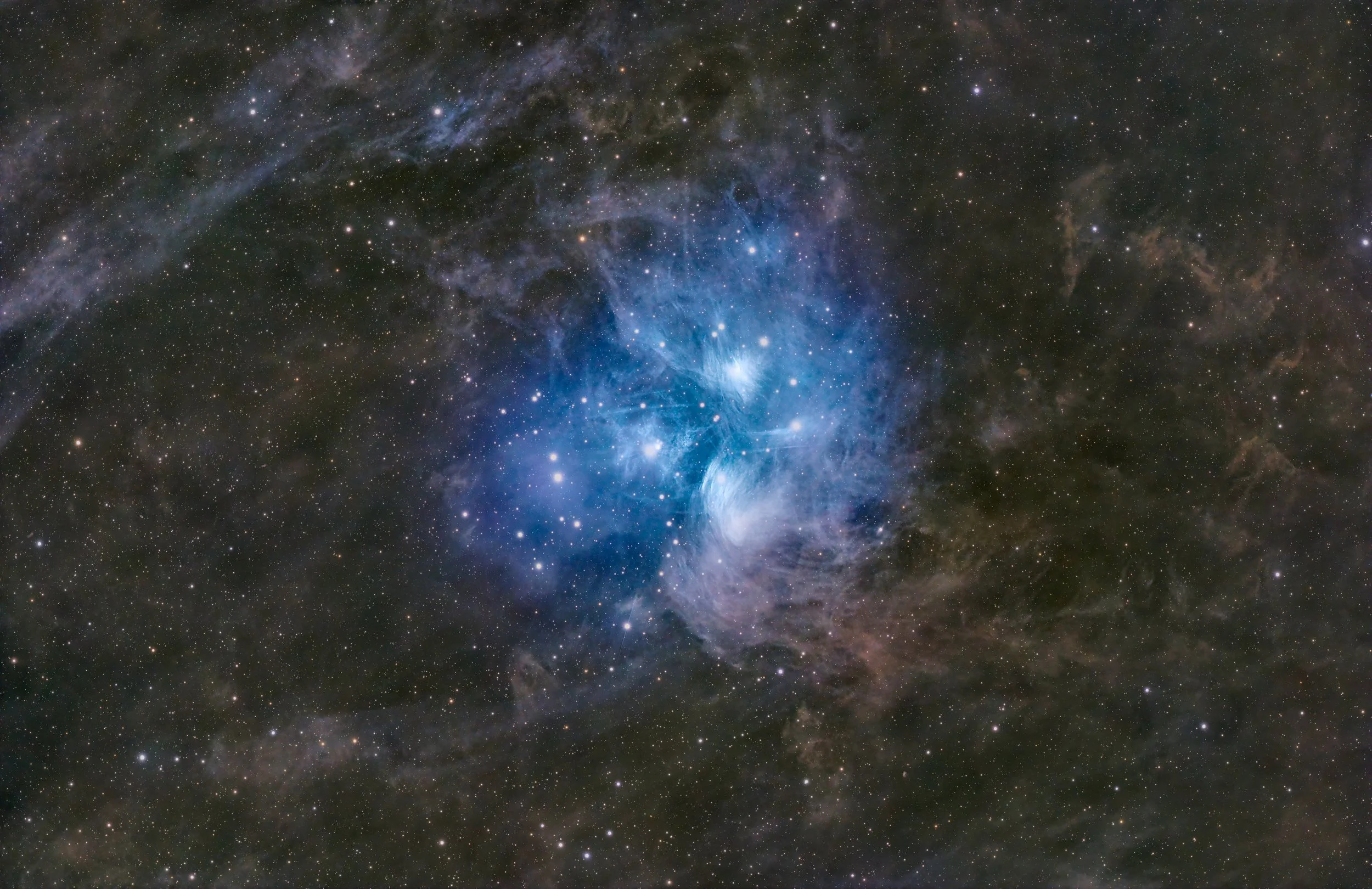 A deep space photograph of a nebula with swirling blue and gray gas and a field of stars.