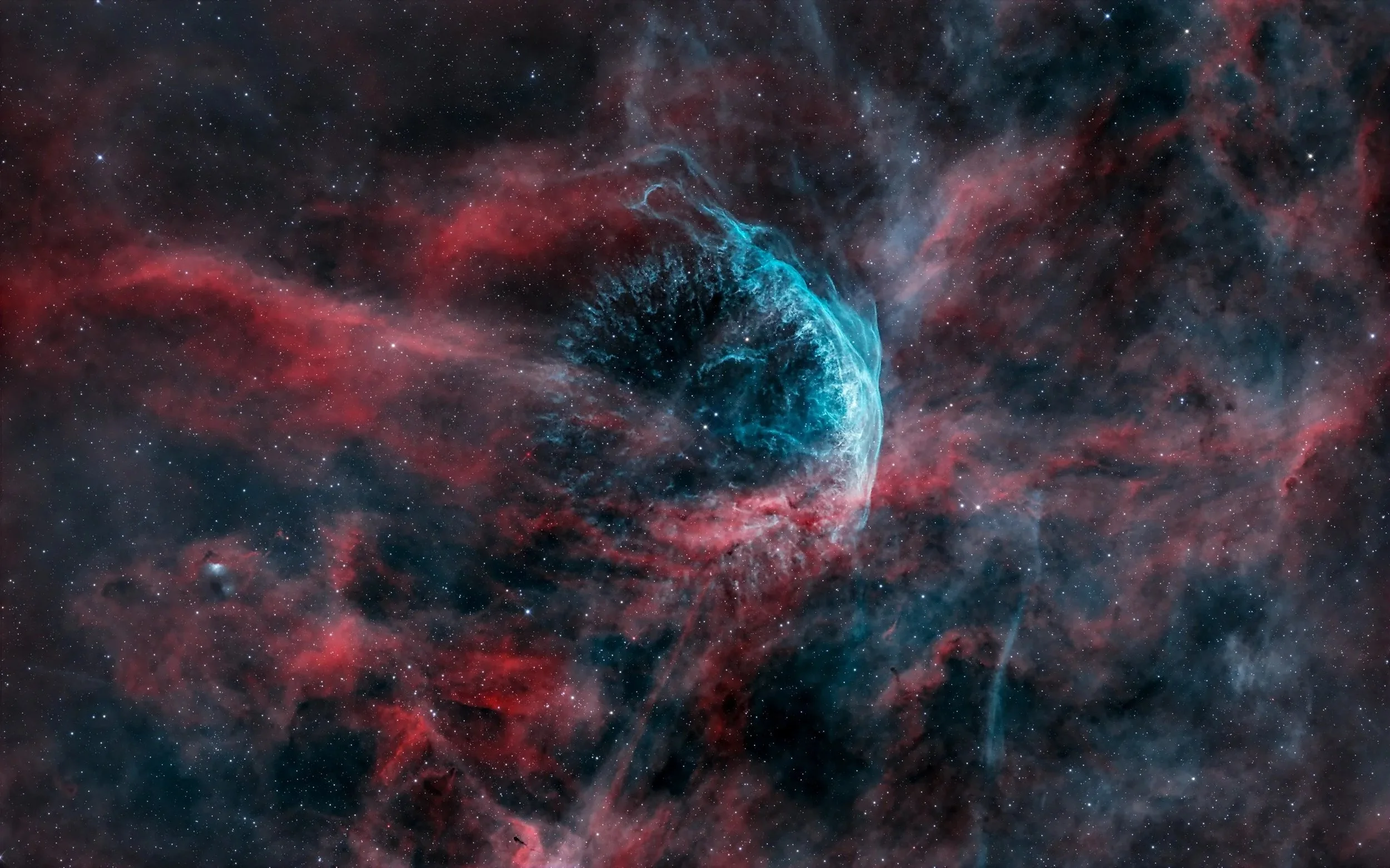 A colorful deep space nebula with a prominent blue and black spherical structure surrounded by red, pink, and dark clouds of cosmic dust and stars.