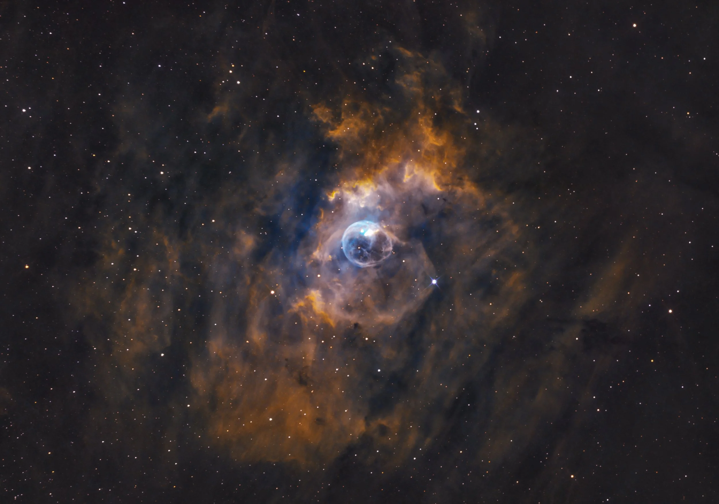 A distant nebula and exploding star in space with bright clouds of gas and dust, and stars scattered throughout