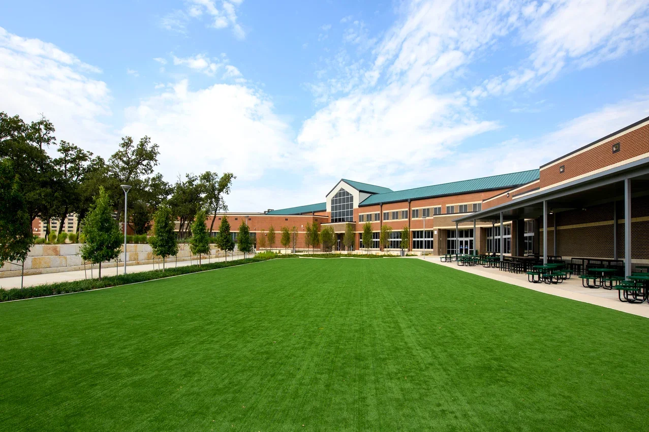 Completed Birdville High School courtyard renovation in Birdville ISD featuring new canopy, landscaping, and outdoor student seating.
