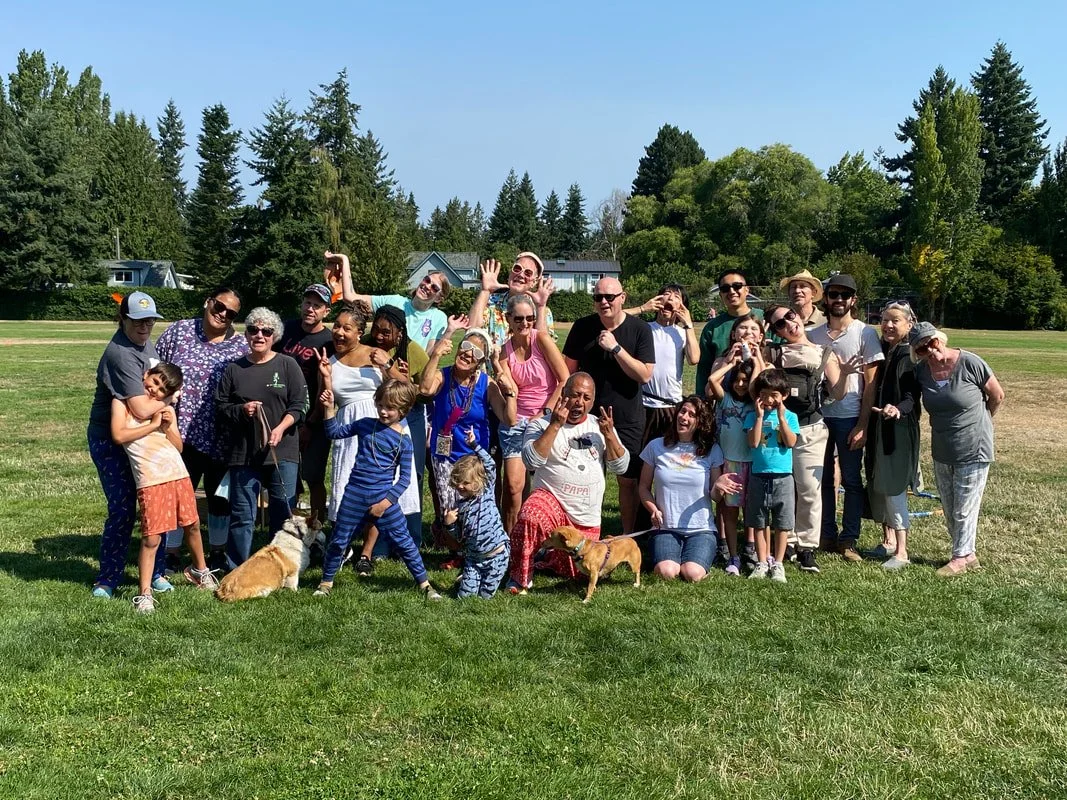 A large group of Walk-a-thon participants smiling after finishing their laps at Lake Burien Memorial Park on a sunny fall morning.