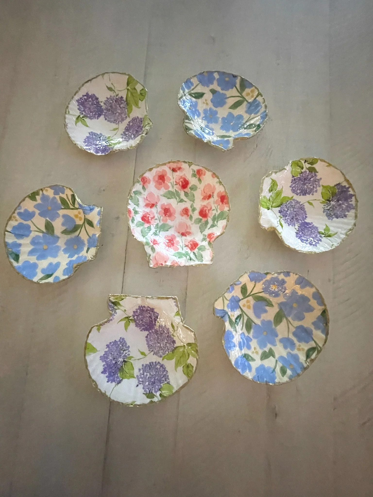 Colorful floral-patterned paper bowls on a tiled floor.