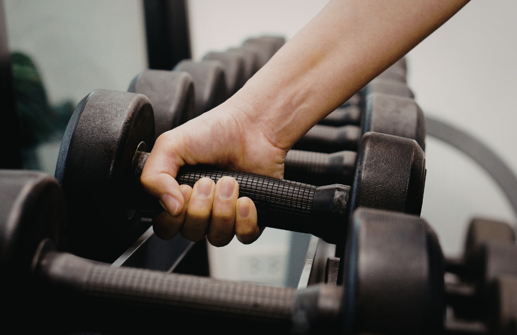 Hand lifting a dumbbell of the rack