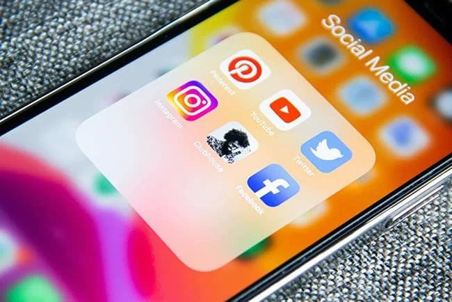 A smartphone screen displaying a folder labeled 'Social Media' with icons for Pinterest, Instagram, YouTube, Twitter, Clash of Clans, and Facebook.