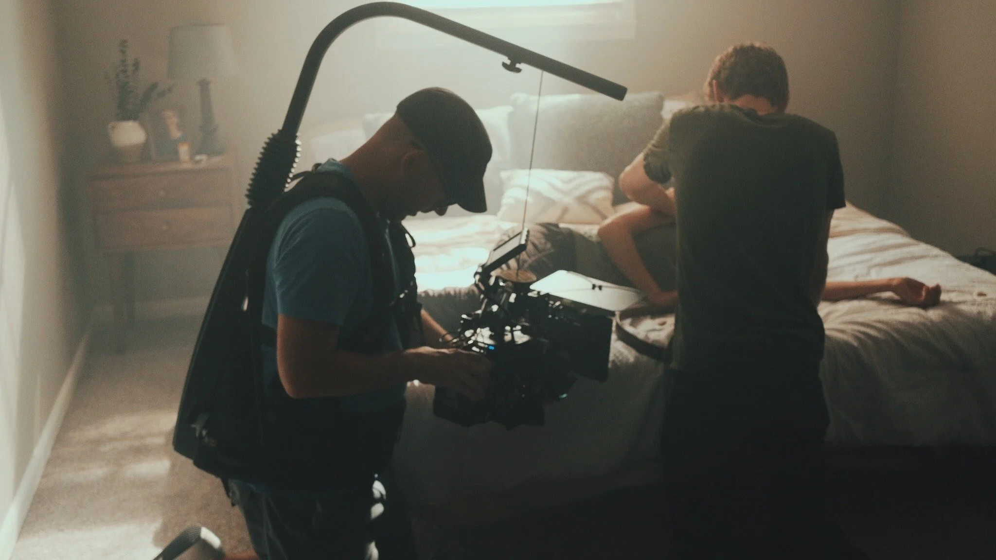 Filmmakers filming scene in a bedroom with haze for video production.